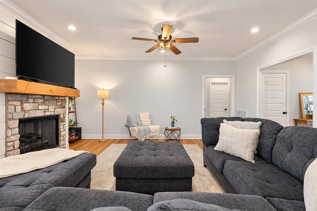 Living room centered on a stone gas-log fireplace with a wood mantel