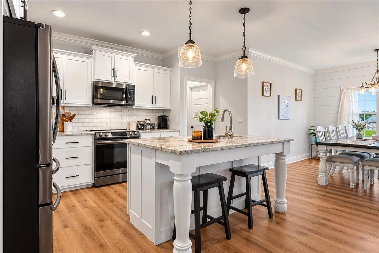 Kitchen and dining area with island seating and a chandelier over the table