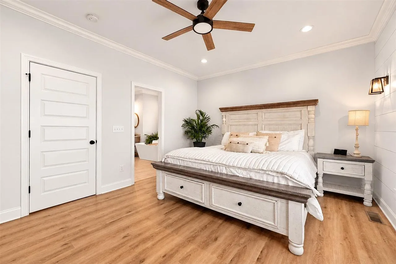 Primary suite with shiplap wall, wood-toned flooring, and a calm neutral palette