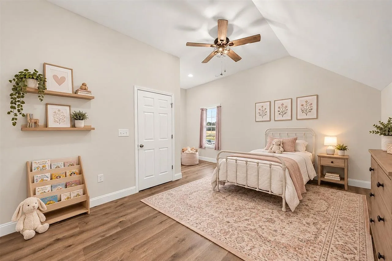 Secondary bedroom with a vaulted ceiling and wood-look plank flooring
