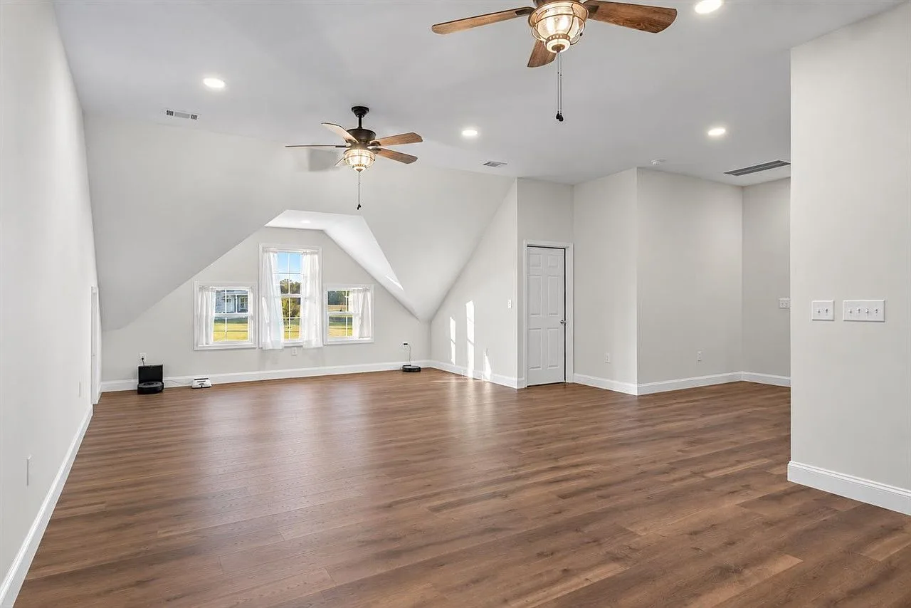 Second view of the upstairs bonus room with vaulted ceilings and recessed lighting