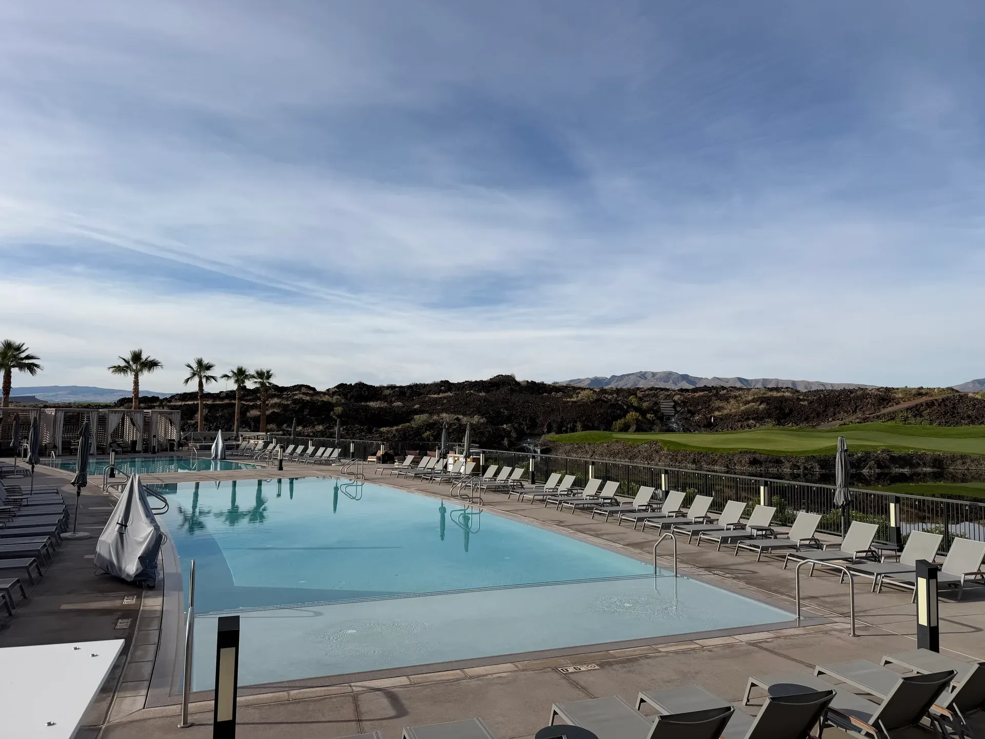 Resort style swimming pool at Black Desert with lounge chairs and shaded seating