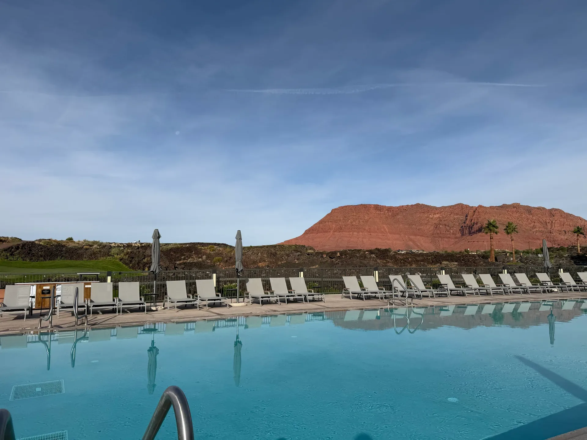 Community swimming pool at Black Desert with rows of poolside loungers