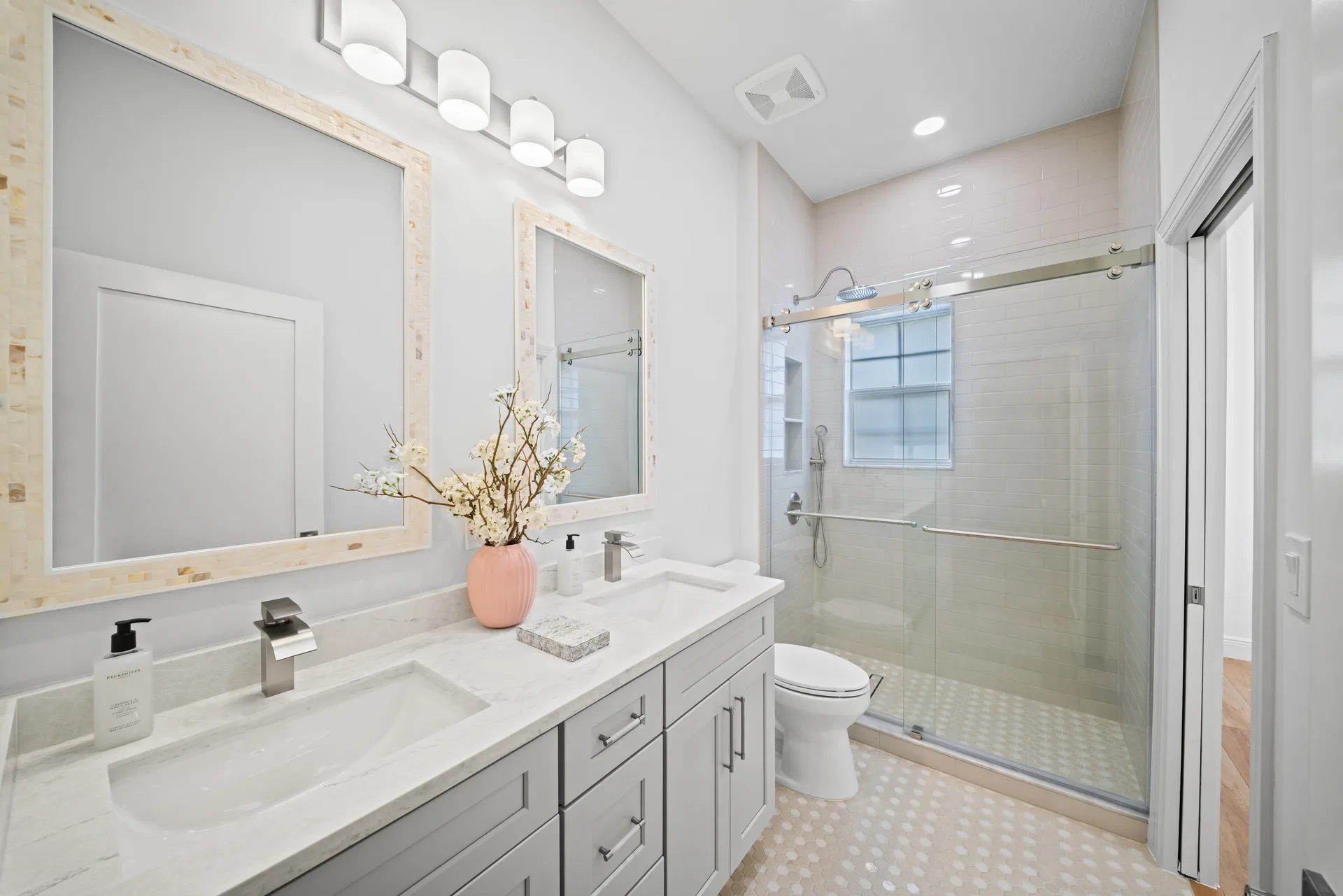 Primary bathroom dual-sink vanity with light gray cabinetry