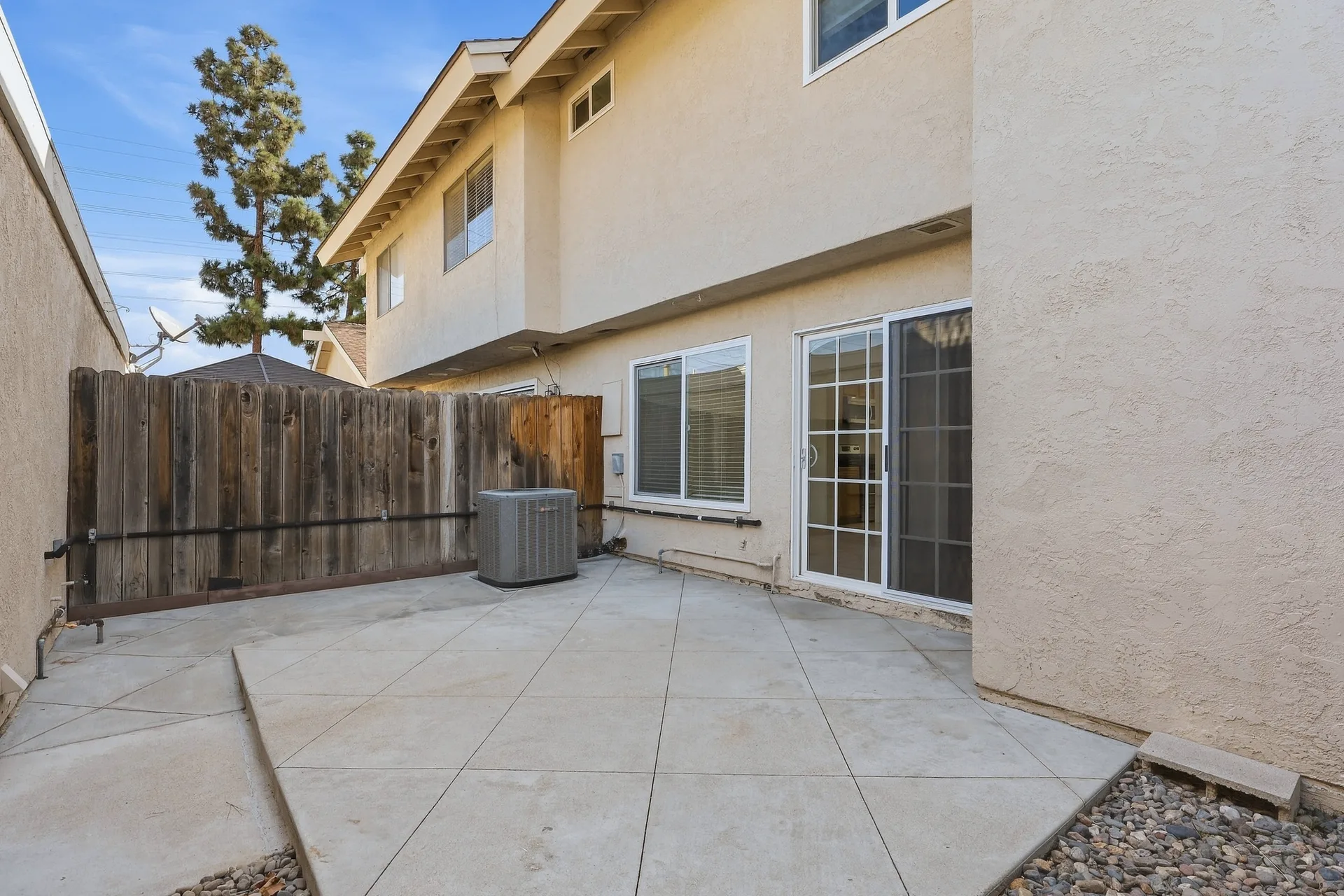 Secluded patio space at 8 Silverwood enclosed by a wood privacy fence under a clear sky