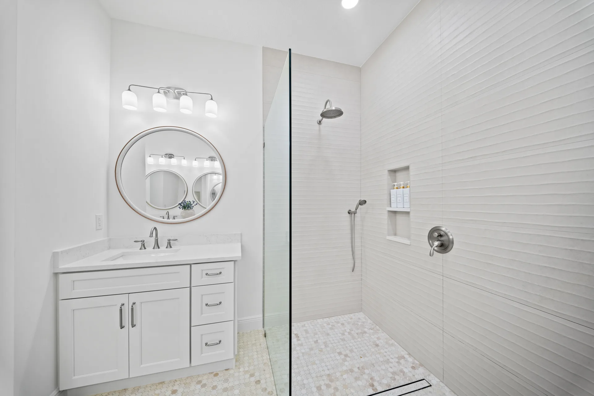 Bathroom vanity with marble-look countertops and walk-in shower
