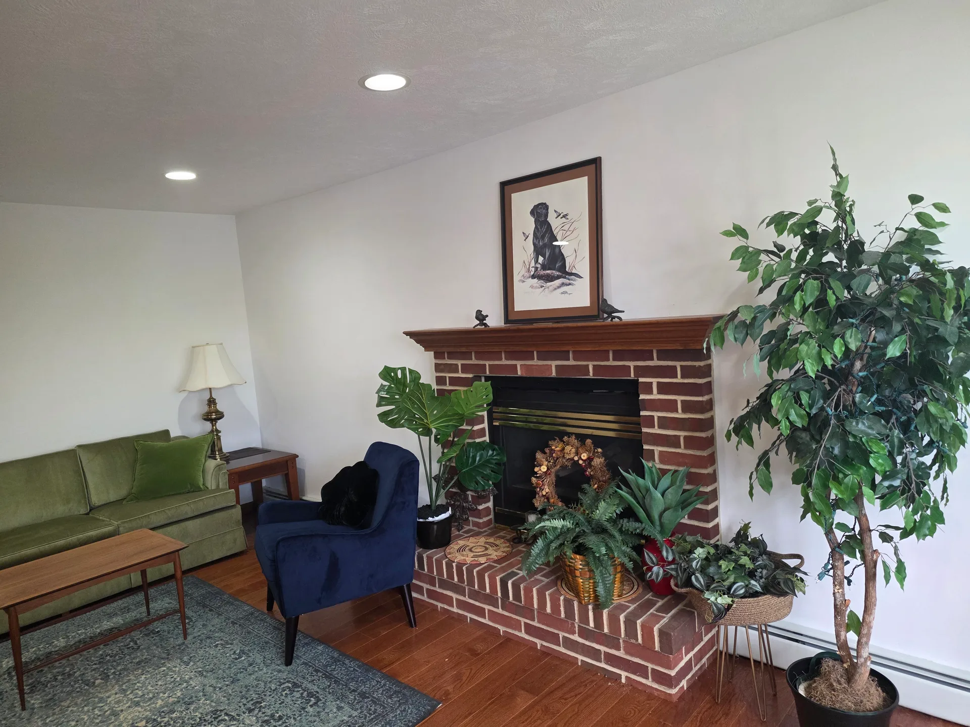 Living room with brick fireplace, wood mantel, and recessed ceiling lights