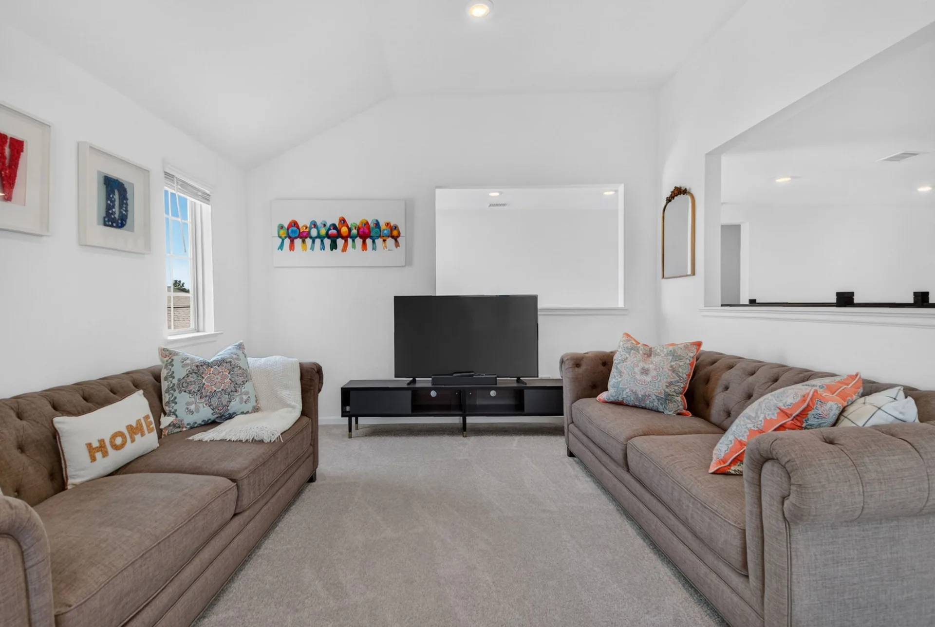 Bright bonus living space with vaulted ceilings and a large window wall