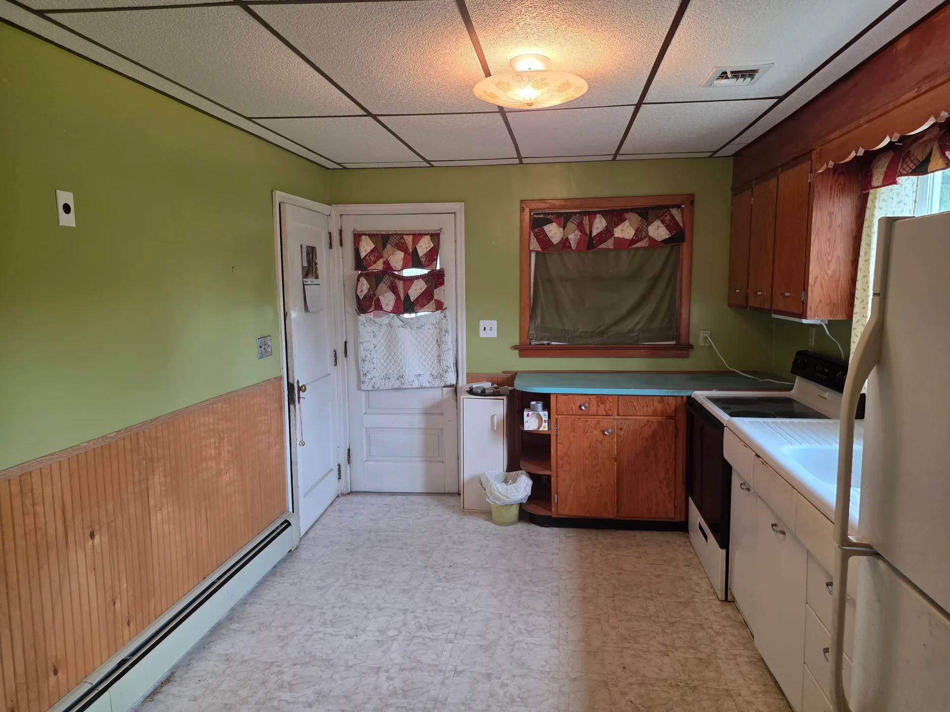 Eat-in kitchen with wood wainscoting and natural light from windows