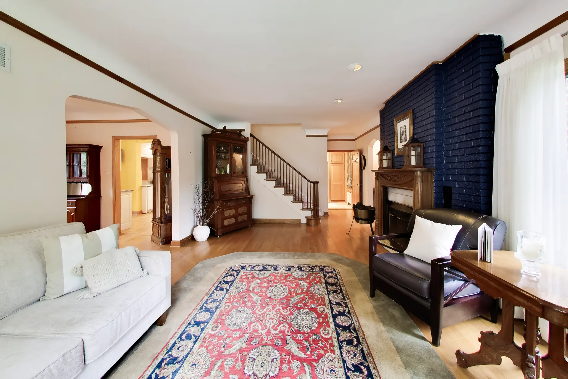 Living room and staircase with fireplace and hutch