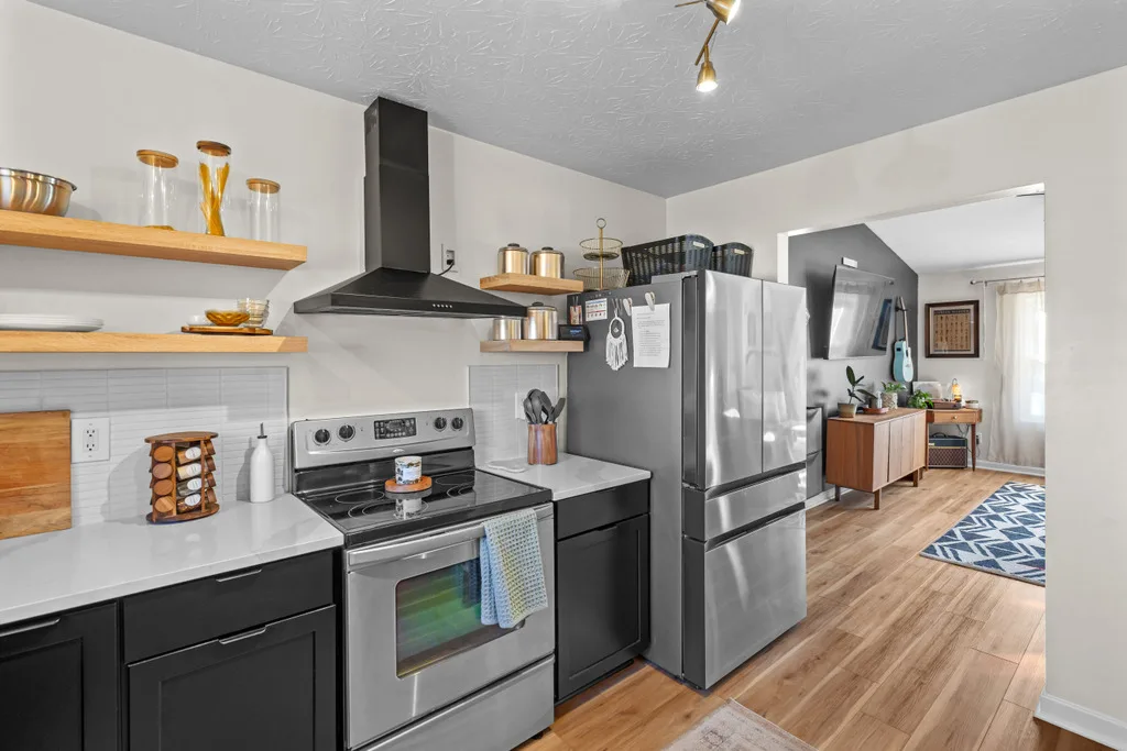 Modern kitchen with black cabinetry, white quartz counters and stainless appliances