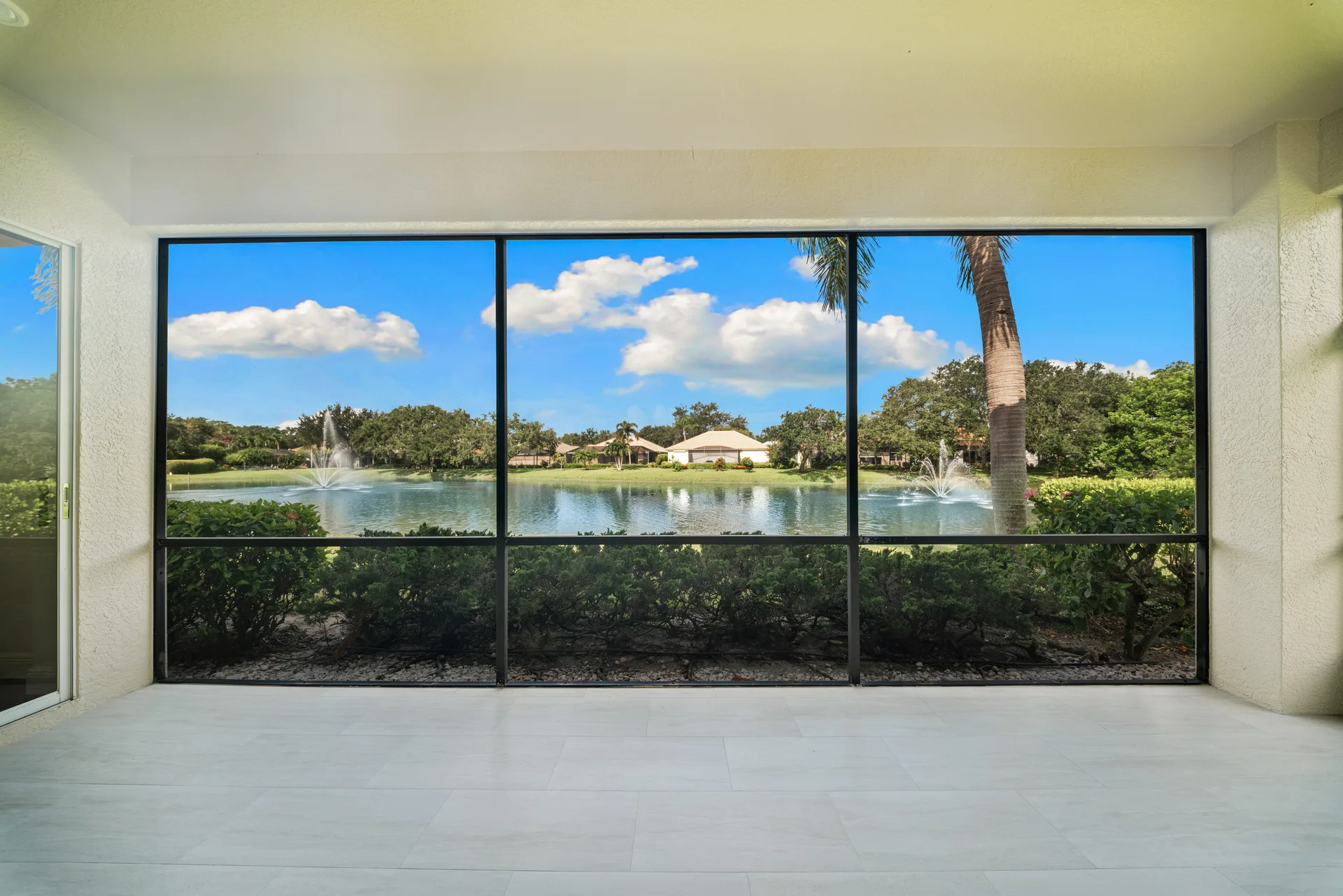 Screened lanai overlooking lake with fountain views
