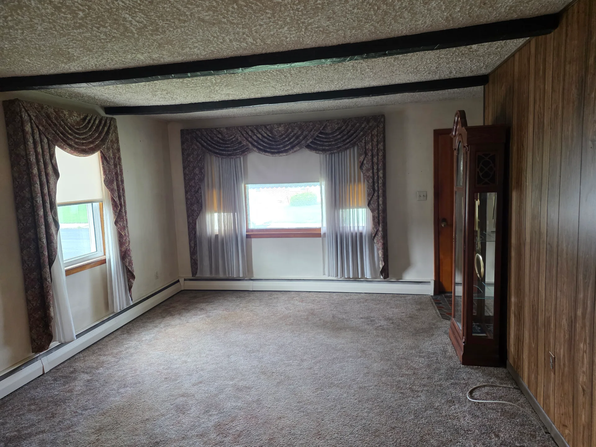 Living room with wood paneling and exposed beams