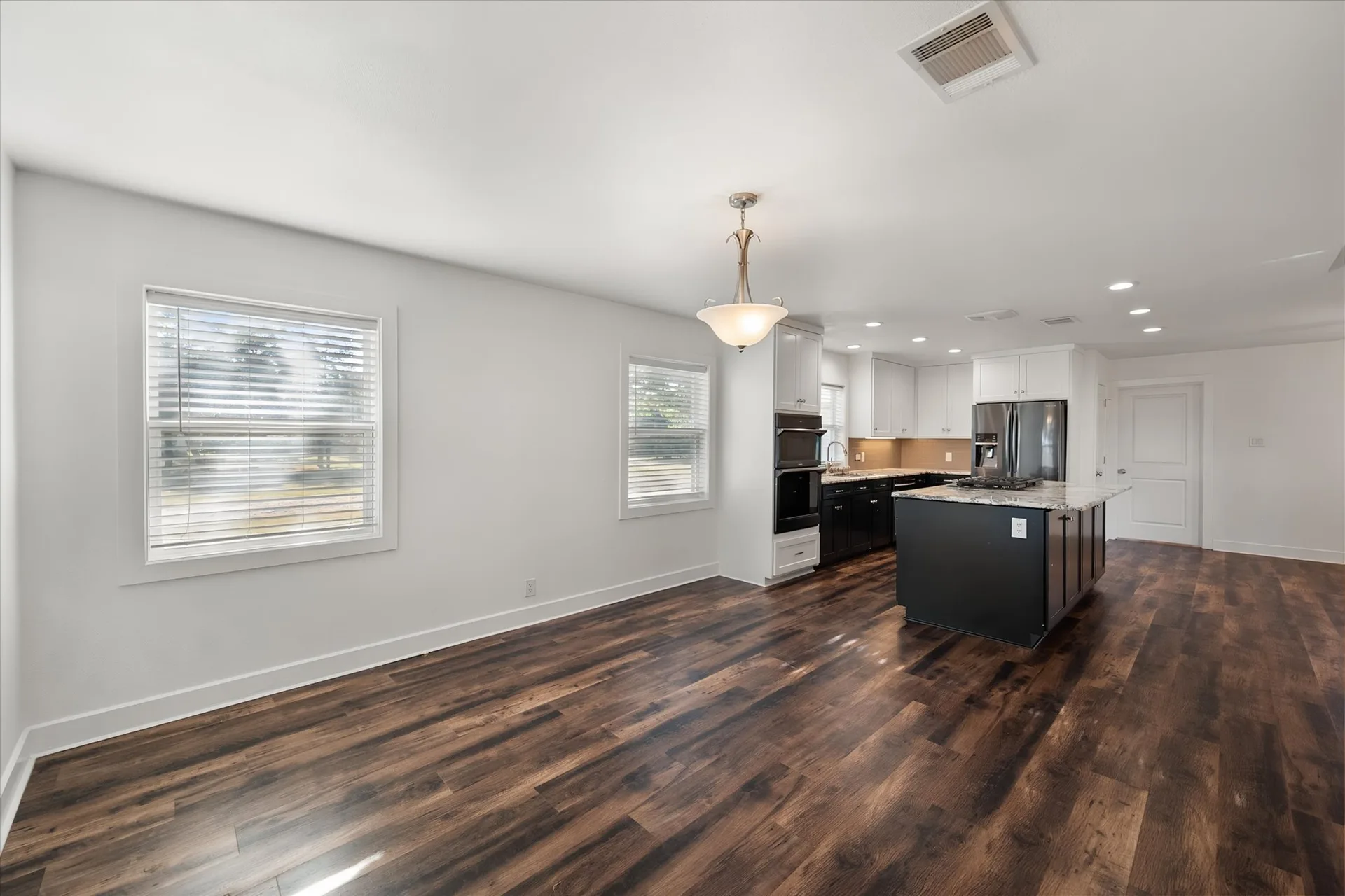 Open-plan kitchen and dining area with dark island and white counters