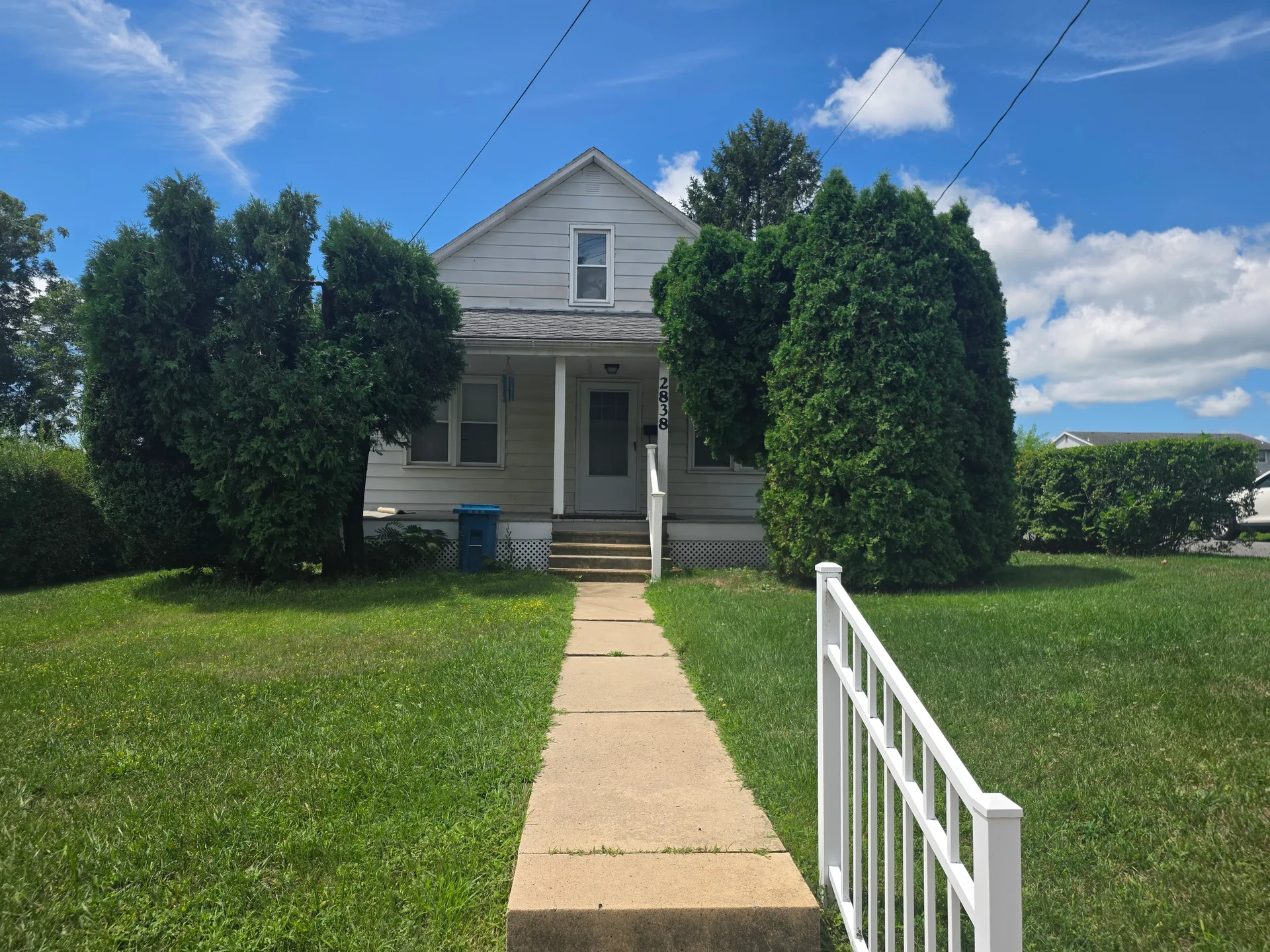 Front exterior of 2838 Cherryville Rd, a classic Cape Cod home with white siding and mature landscaping under a clear blue sky