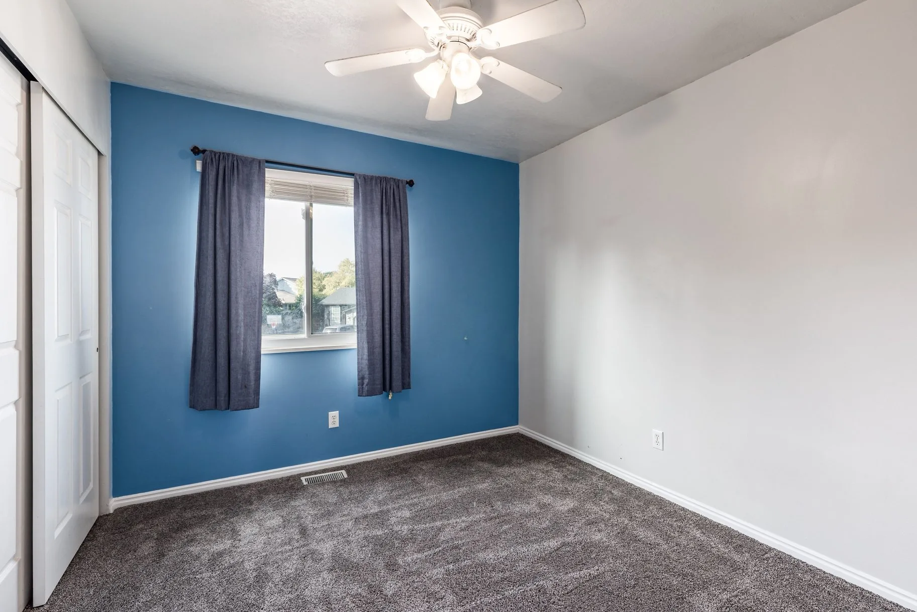 Bedroom with blue accent wall and carpeted flooring