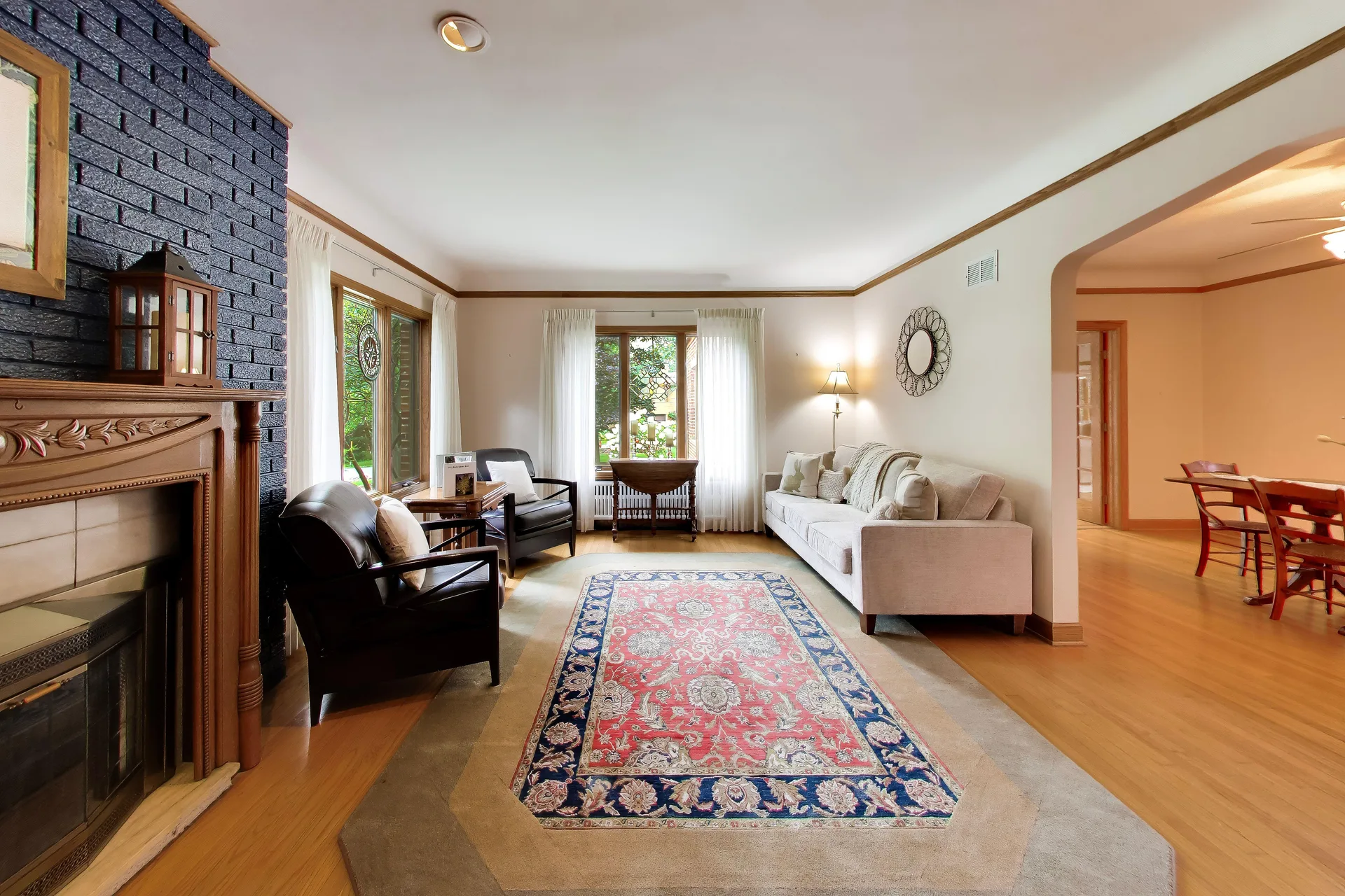 Living room with painted-brick fireplace and hardwoods