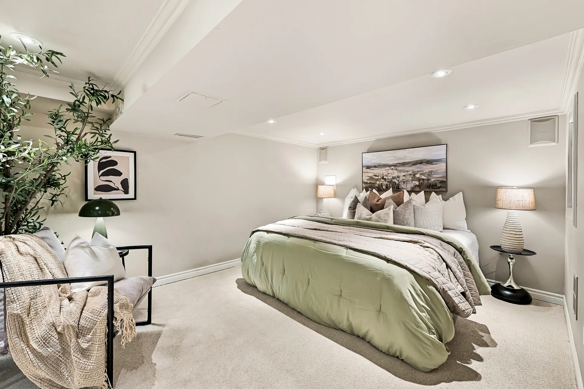 Lower-level bedroom with queen bed and reading chair