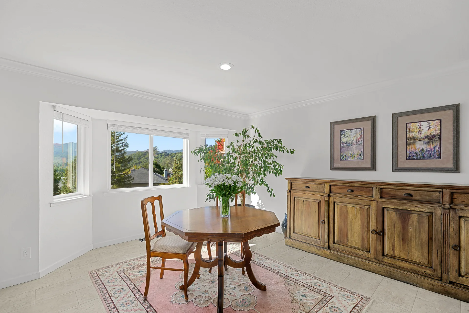 Dining area with a large bay window framing hillside views