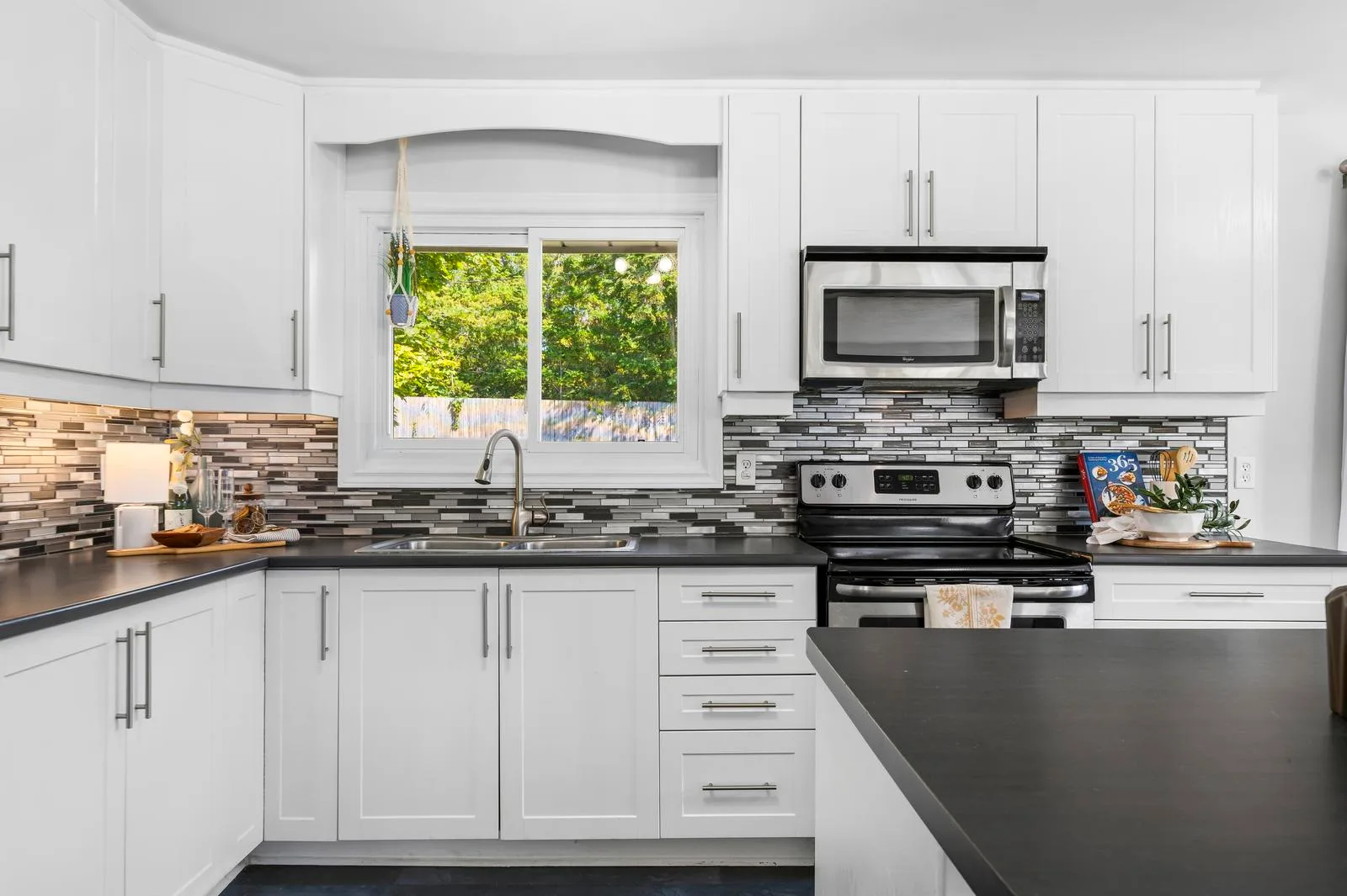 Modern white kitchen with shaker cabinetry and tile backsplash