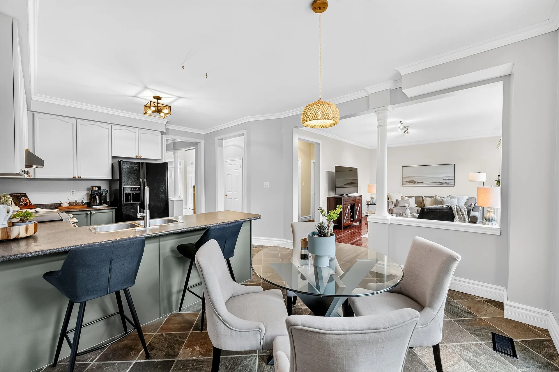 The open-concept kitchen and dining area at 459 Victoria, with sage green cabinetry, a breakfast bar and bright natural light from the garden doors