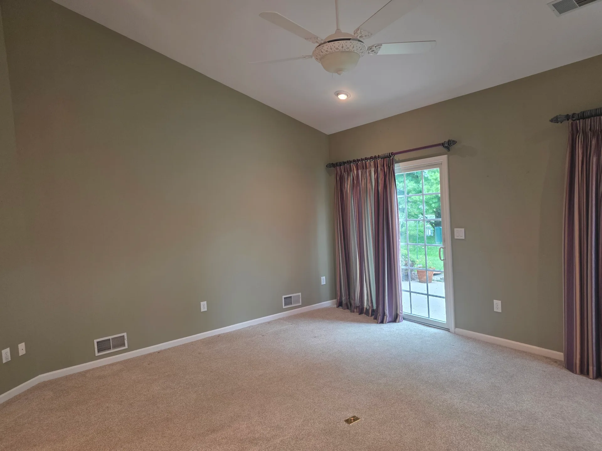 Living room with vaulted ceiling and sliding glass patio doors letting in natural light