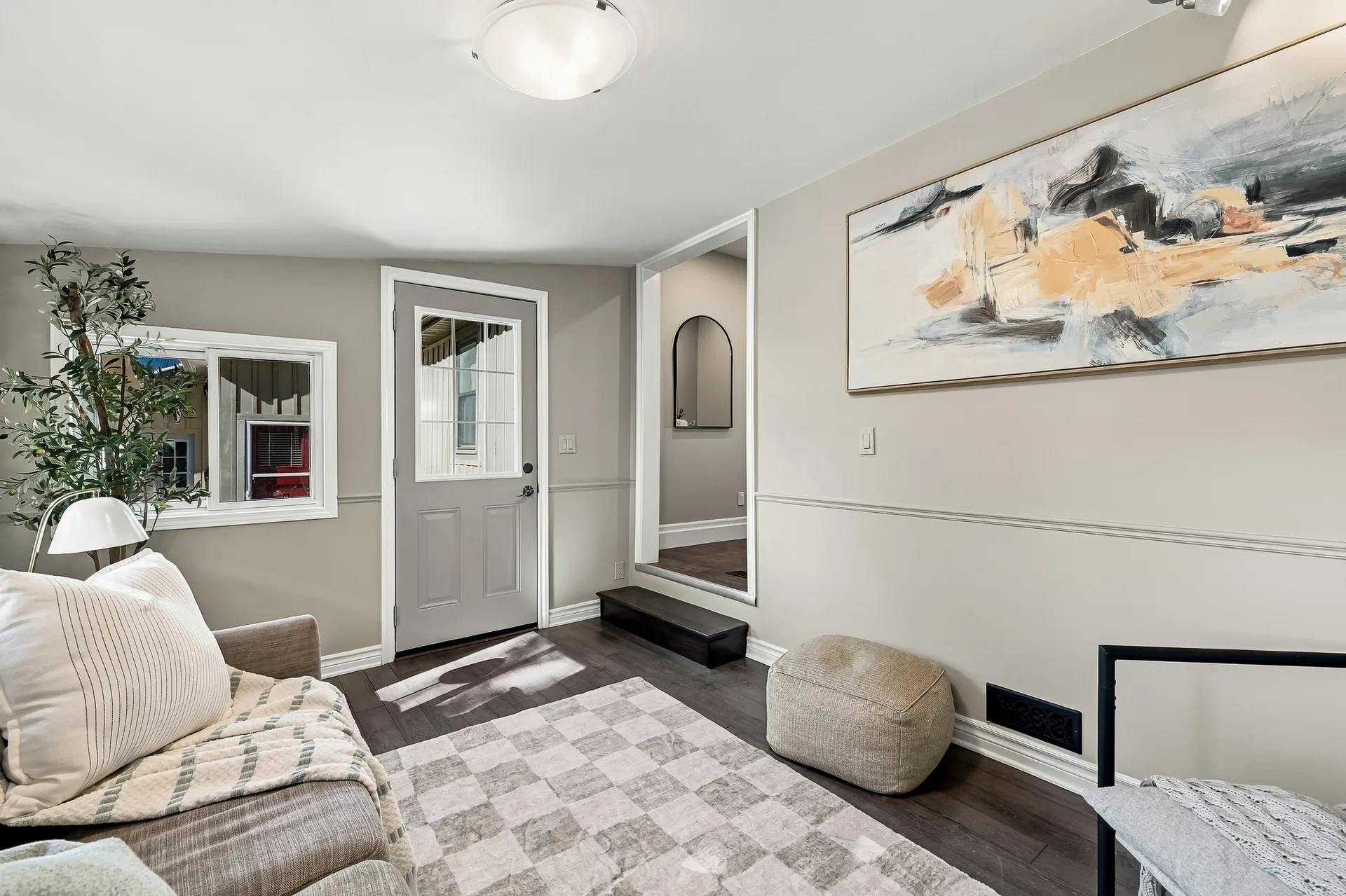 Living and entry area with sofa, rug and large wall art
