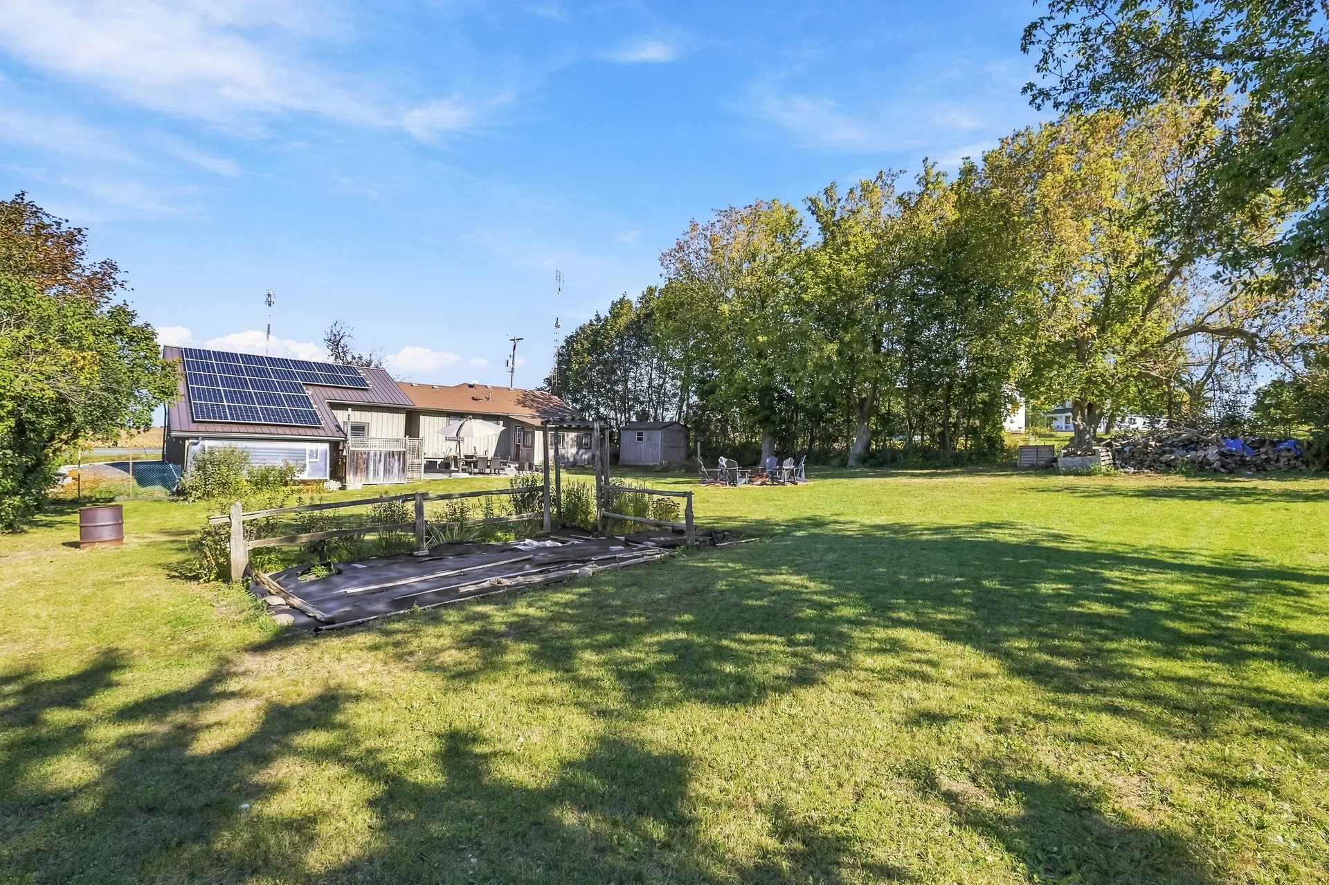 Wide view across the large rural lot toward the rear of the house