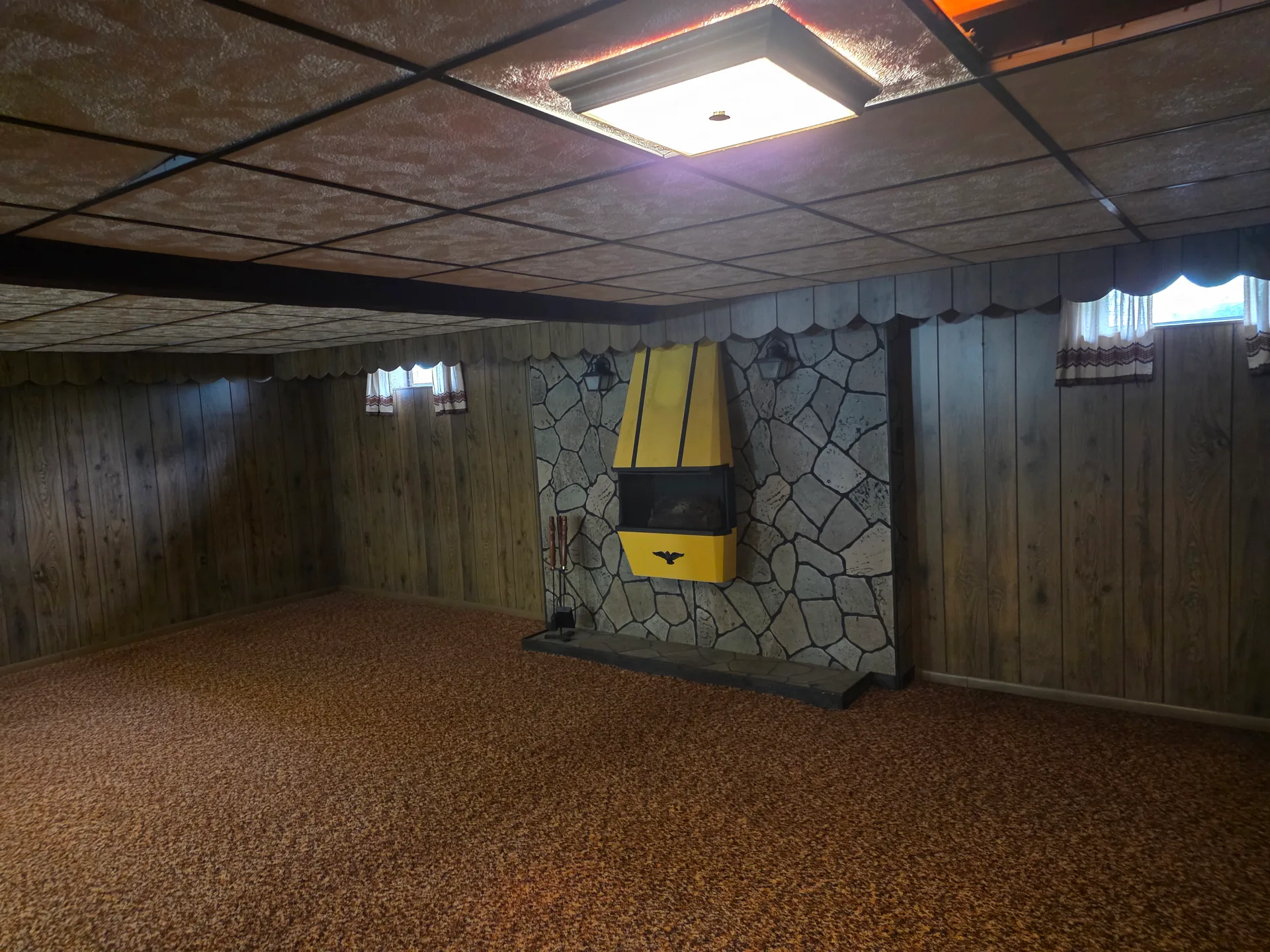 Finished basement recreation room with stone fireplace