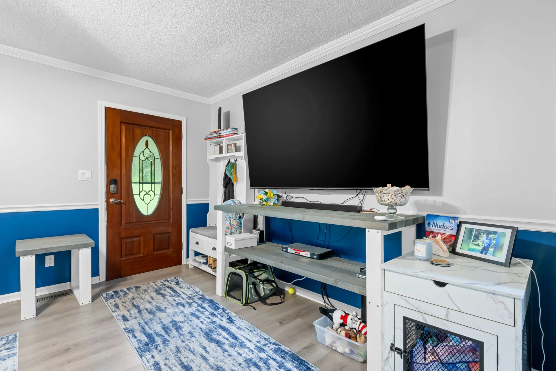 Entryway flowing into the family room, with laminate flooring and a wood front door