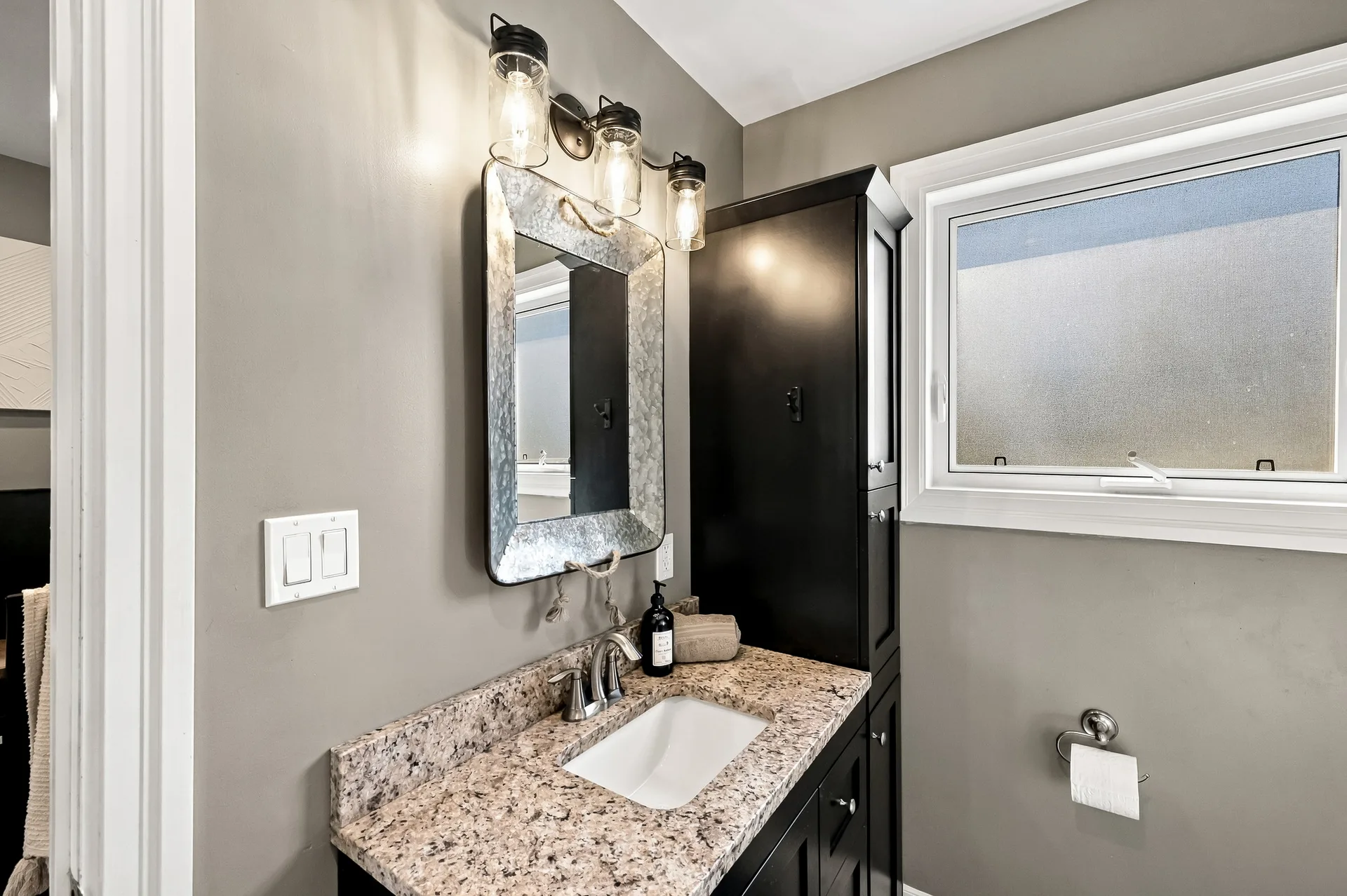 Bathroom vanity with granite countertop and framed mirror