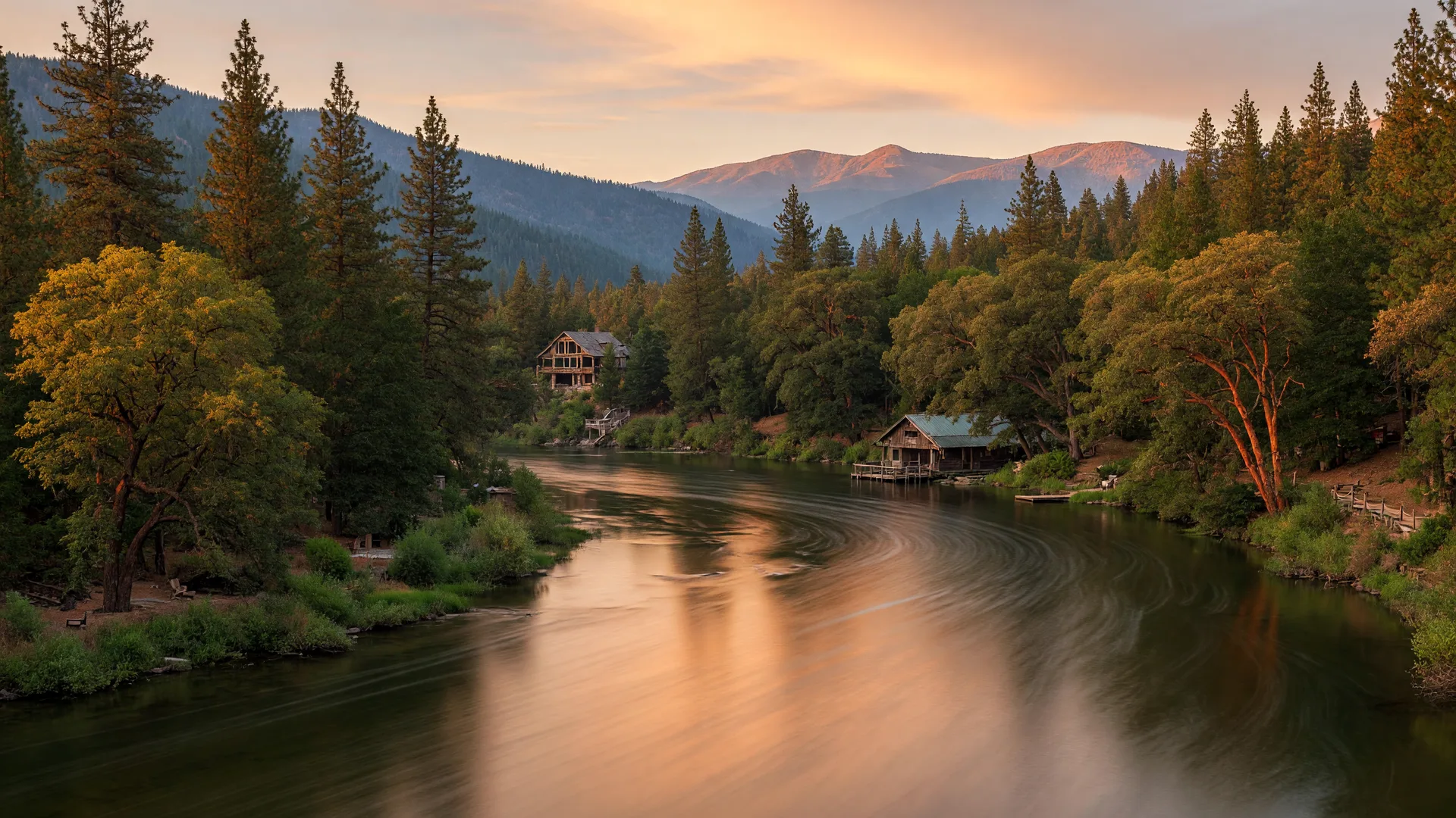 Rogue River at golden hour with riverside properties visible through the trees