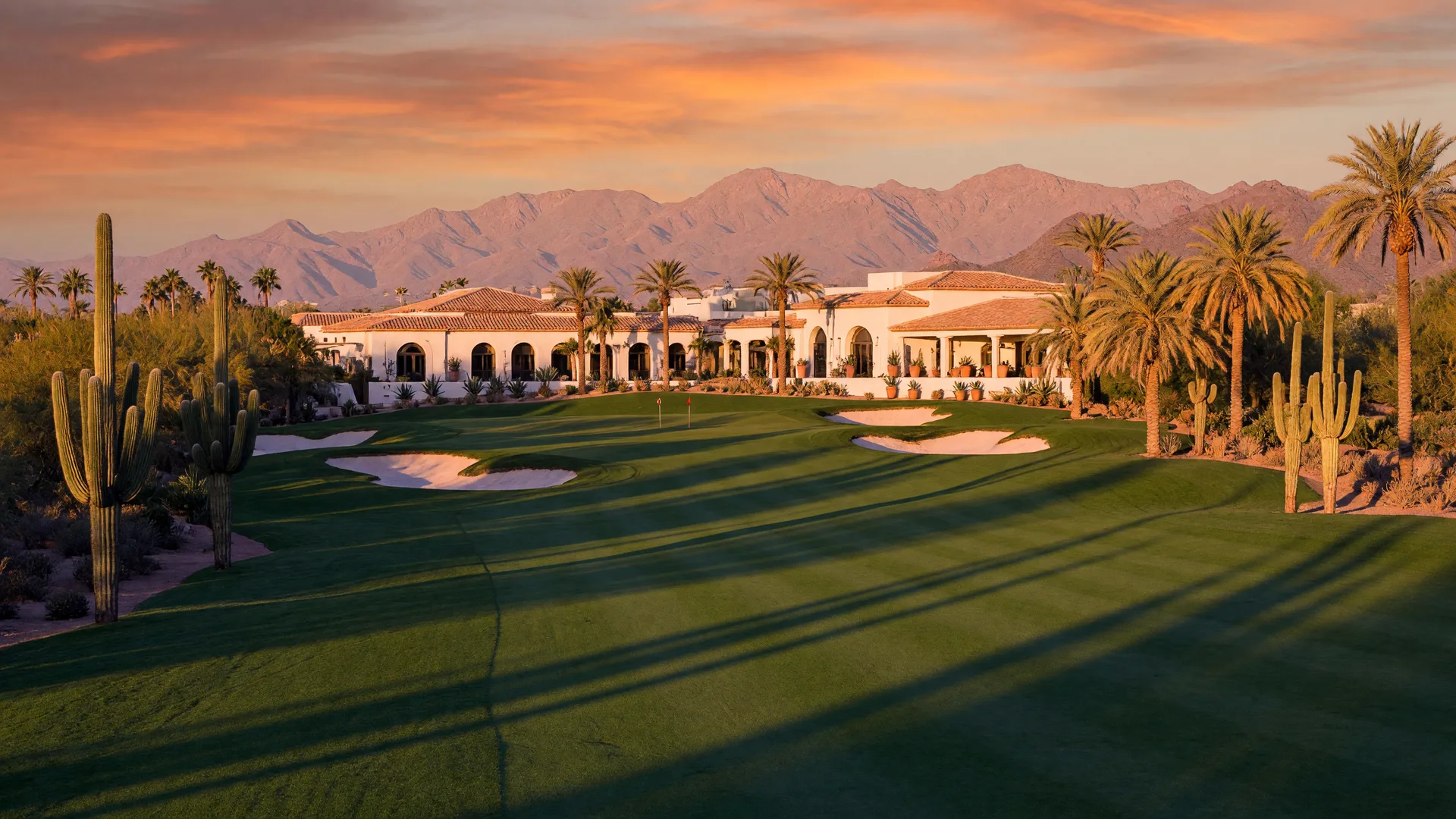 Championship desert golf fairway lined with saguaros and palms in North Scottsdale at golden hour