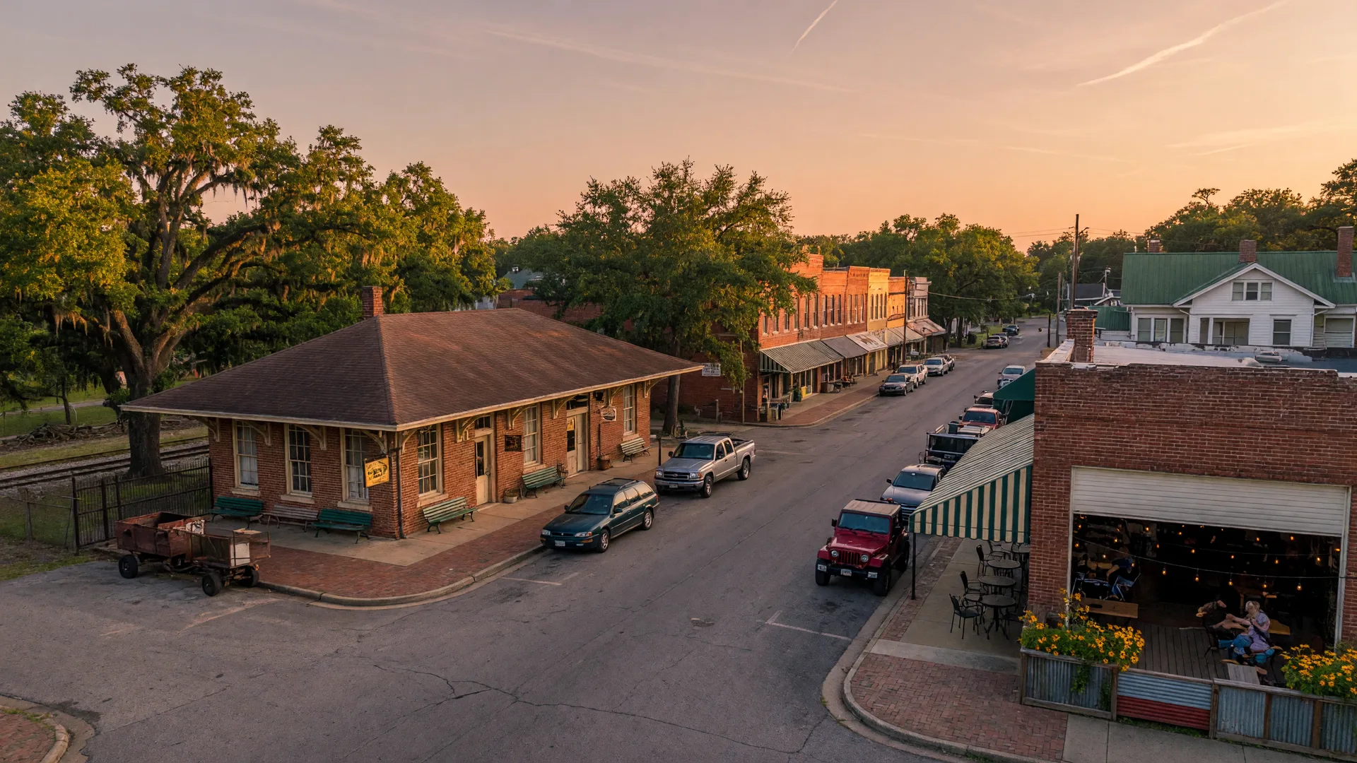 Historic downtown Hapeville Georgia on North Central Avenue at golden hour, with brick storefronts and a restored railroad depot