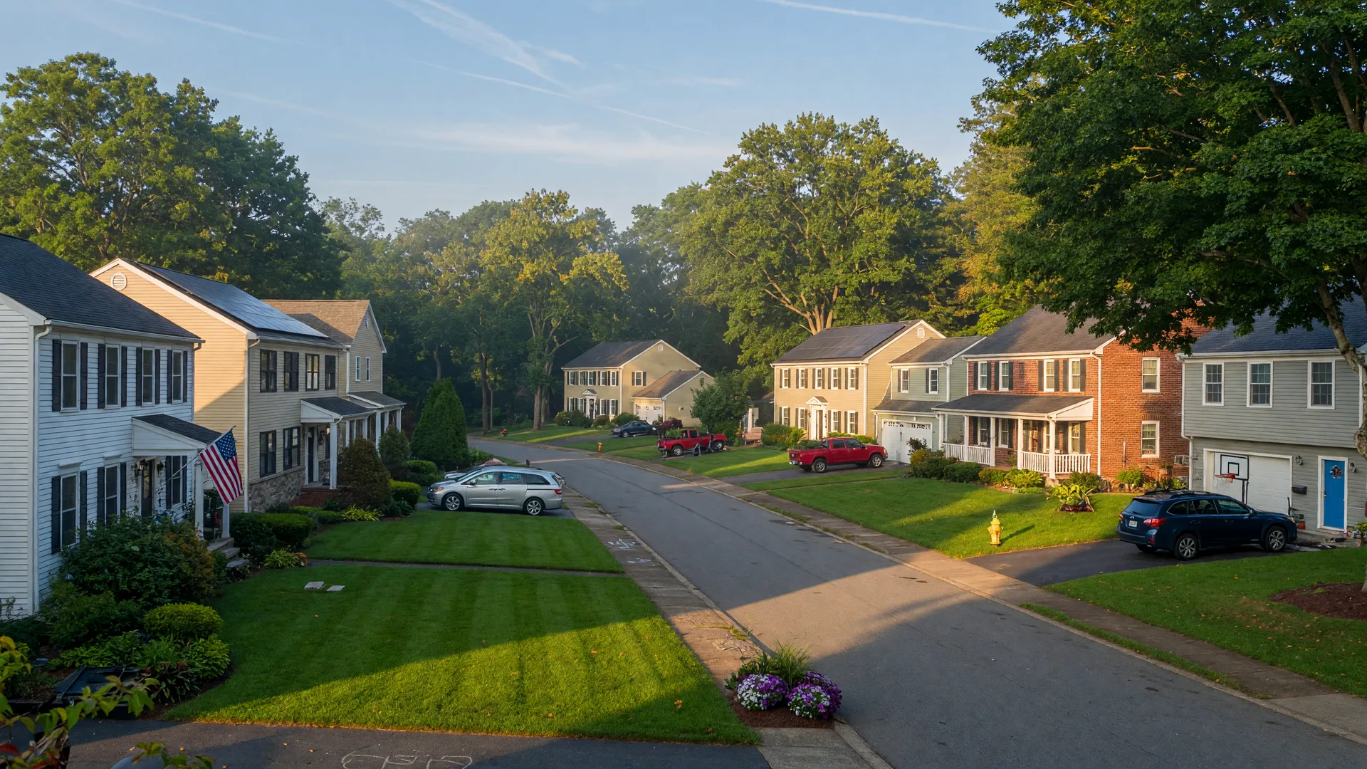 Established family-friendly suburban neighborhood in Voorhees NJ on a late-summer morning with well-maintained homes, manicured lawns, and mature shade trees