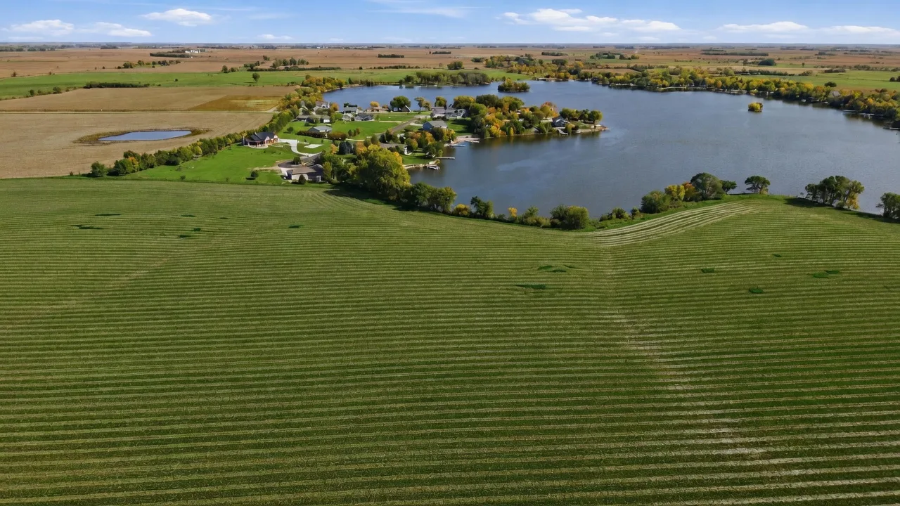 Aerial view of the vacant lakefront lot at 2000 Bright Shores Pl with fields in the foreground and Swan Lake beyond