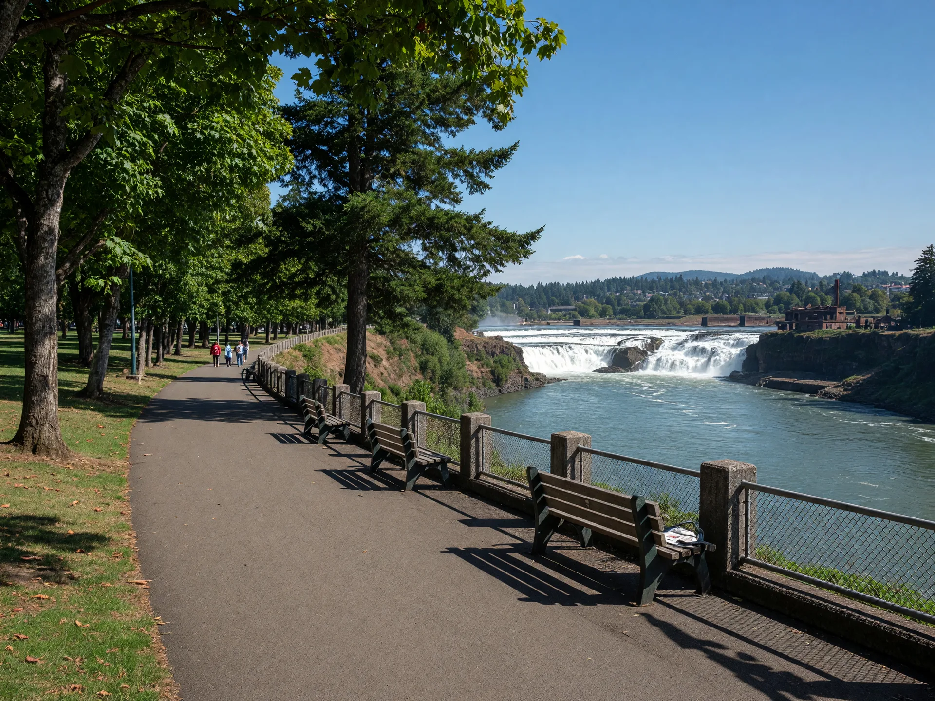 The McLoughlin Promenade walkway in Oregon City overlooking the Willamette River and Willamette Falls on a sunny afternoon