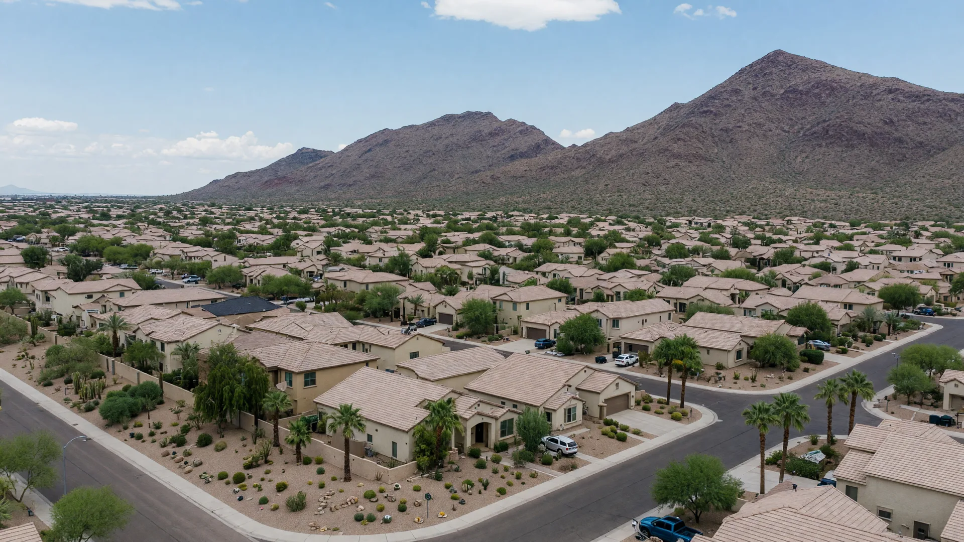 Golden hour aerial view of Chandler, Arizona, with palm-lined neighborhoods stretching toward the San Tan Mountains