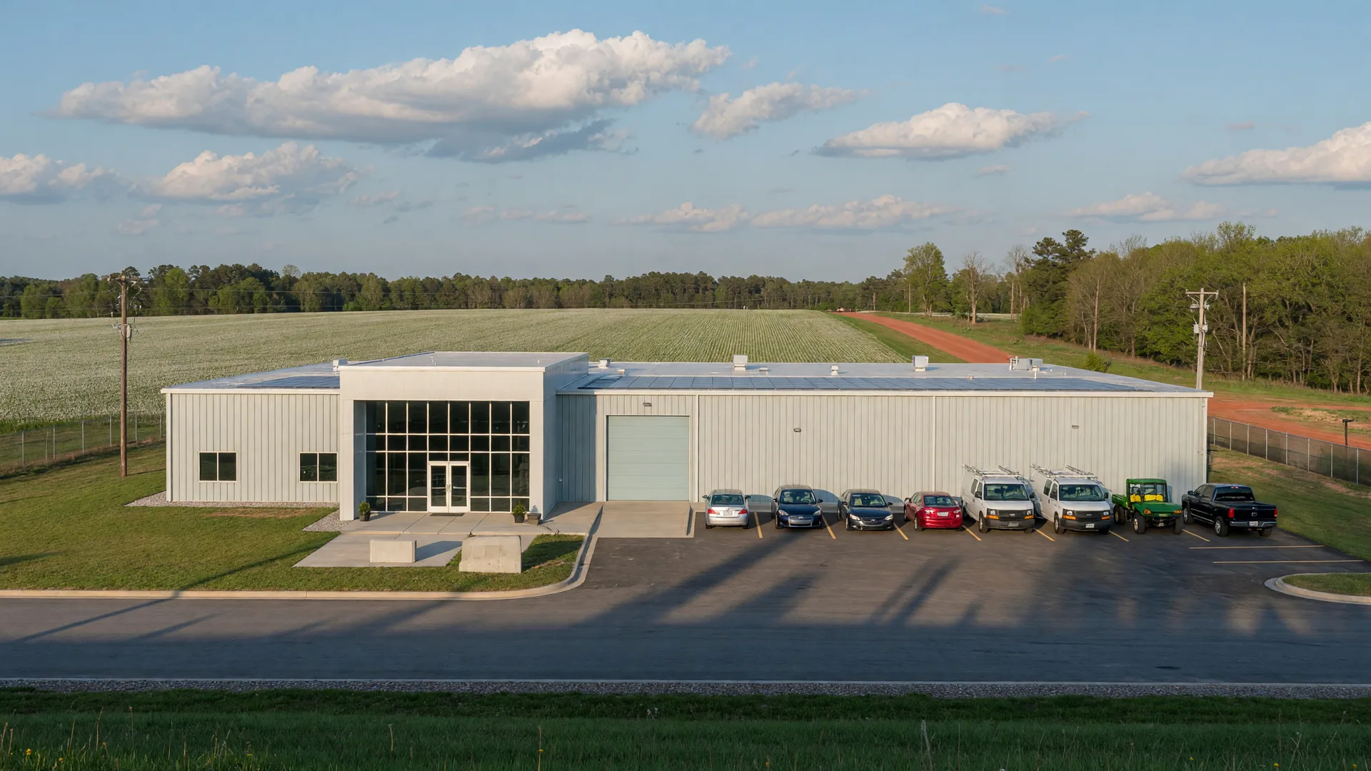 A new single-story manufacturing assembly plant with a glass entry on the edge of a small Georgia town in late afternoon light