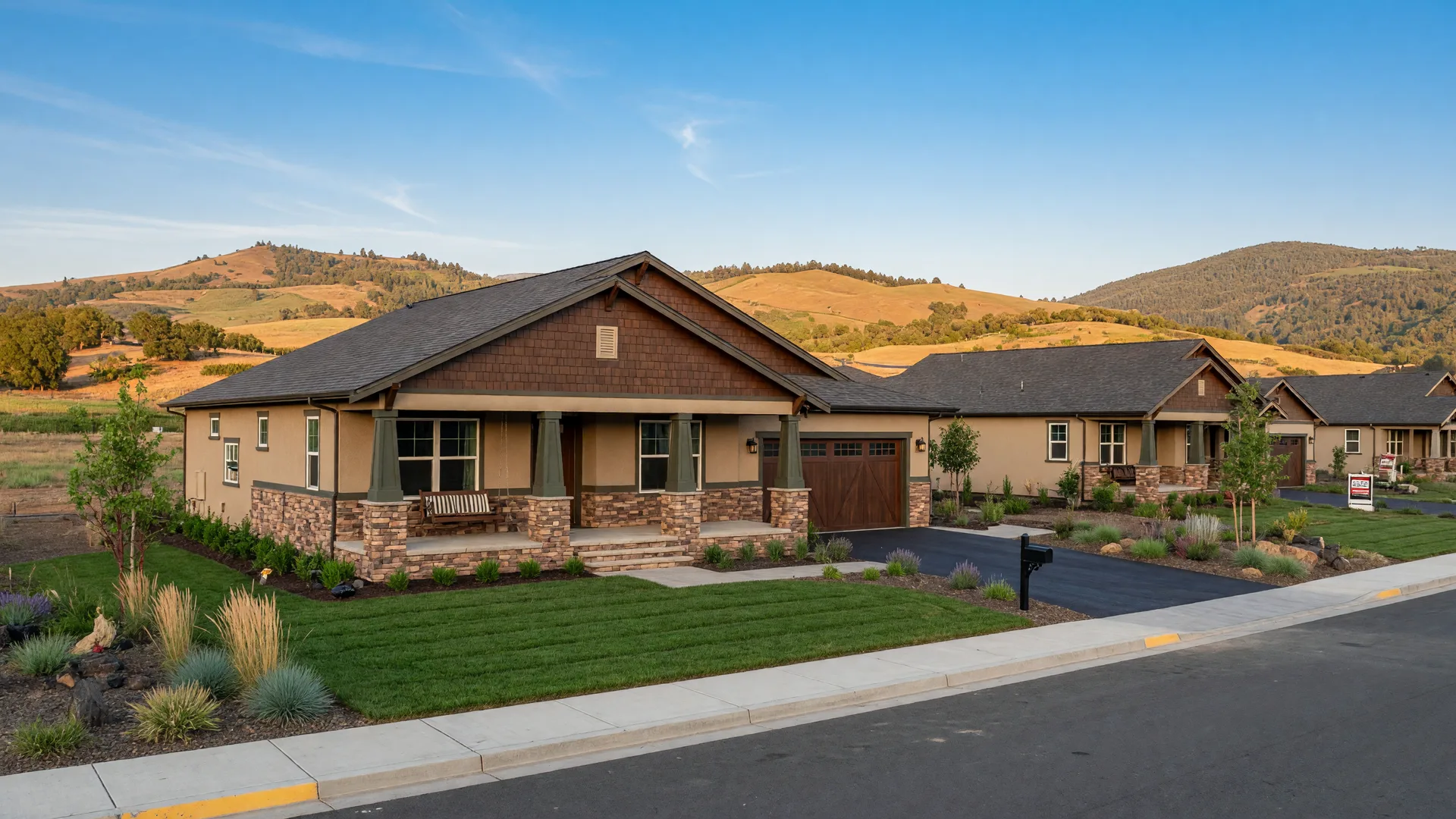 New craftsman-style single-story home with stone accents and desert-toned landscaping in a Medford subdivision, Rogue Valley hills in the distance