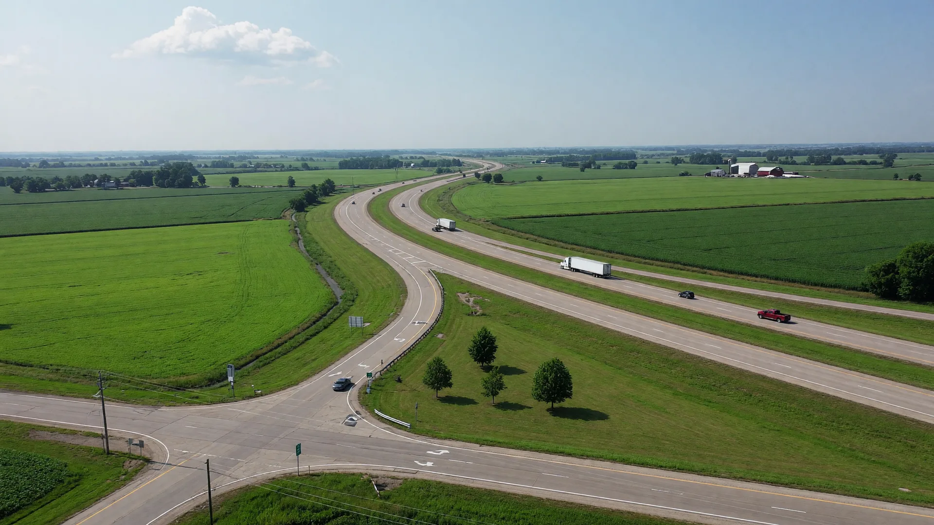 Aerial view of a four-lane interstate curving through green Ohio farmland