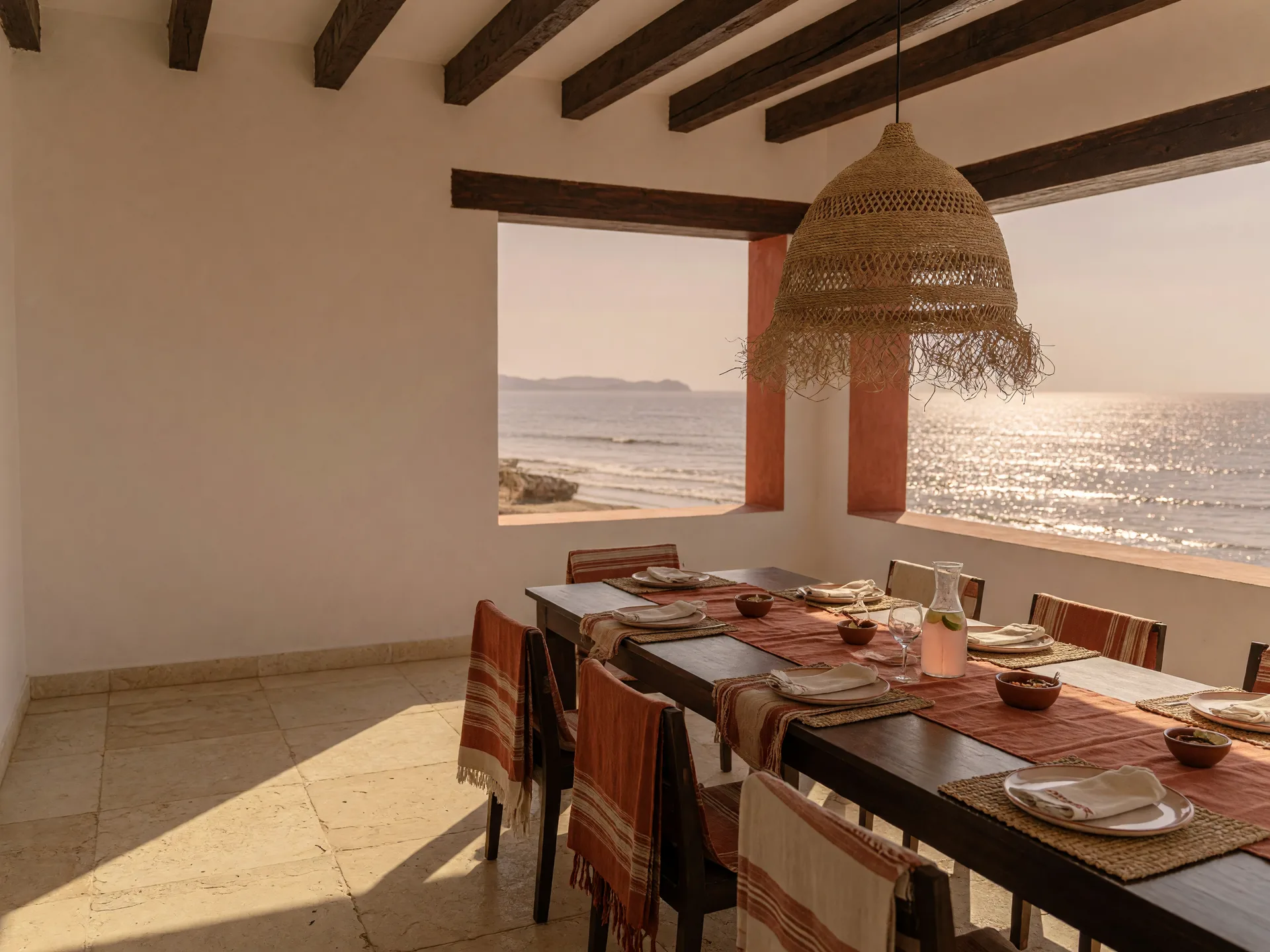 A modern Mexican beachfront terrace opening onto the ocean at late afternoon