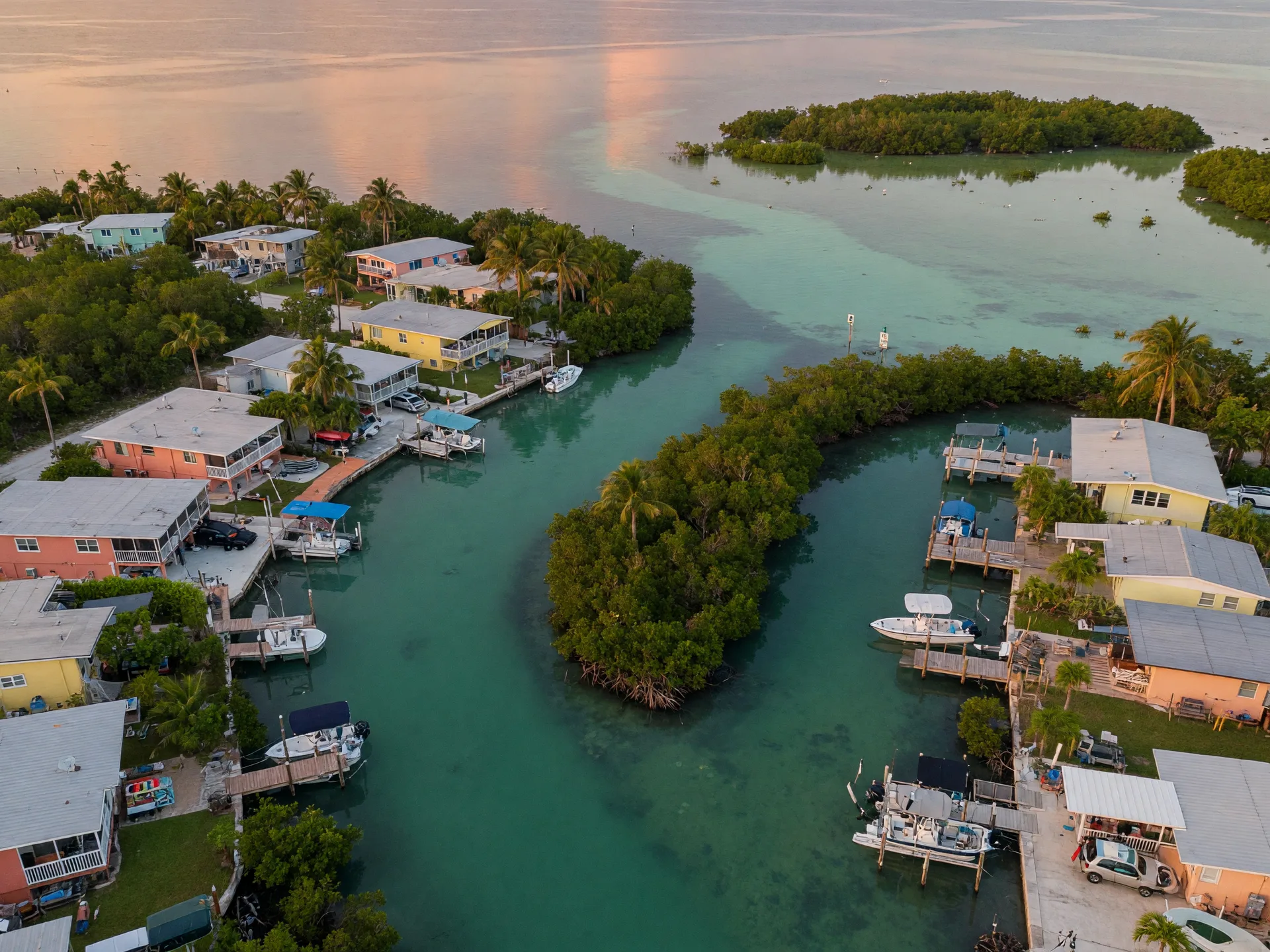 Aerial view of a protected canal neighborhood on Big Pine Key in the Lower Florida Keys with winding turquoise canals, mangrove hammock, and waterfront homes with private docks and boat lifts