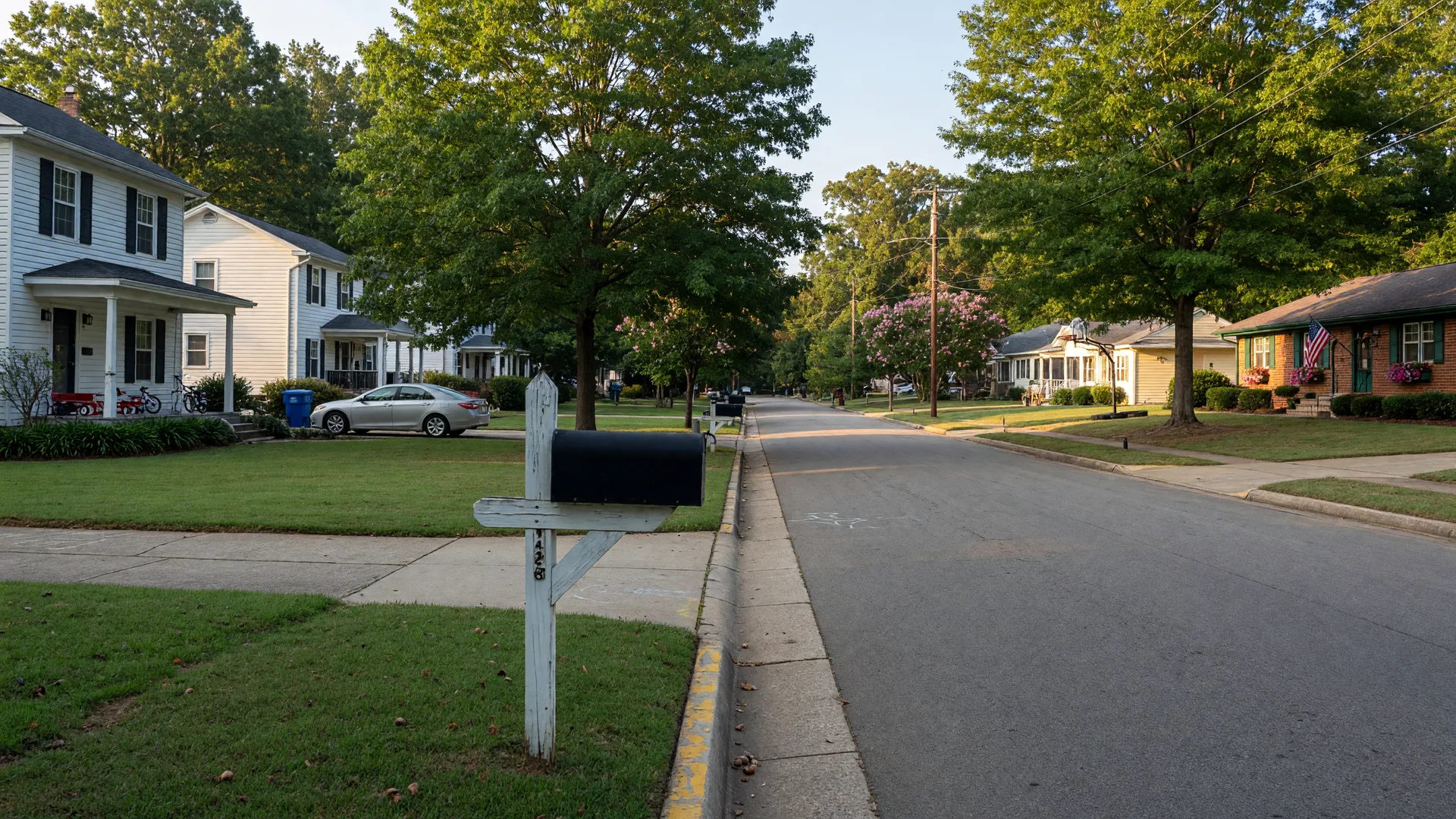 Leafy residential street in Raleigh North Carolina with a mailbox at the curb on a late-summer morning