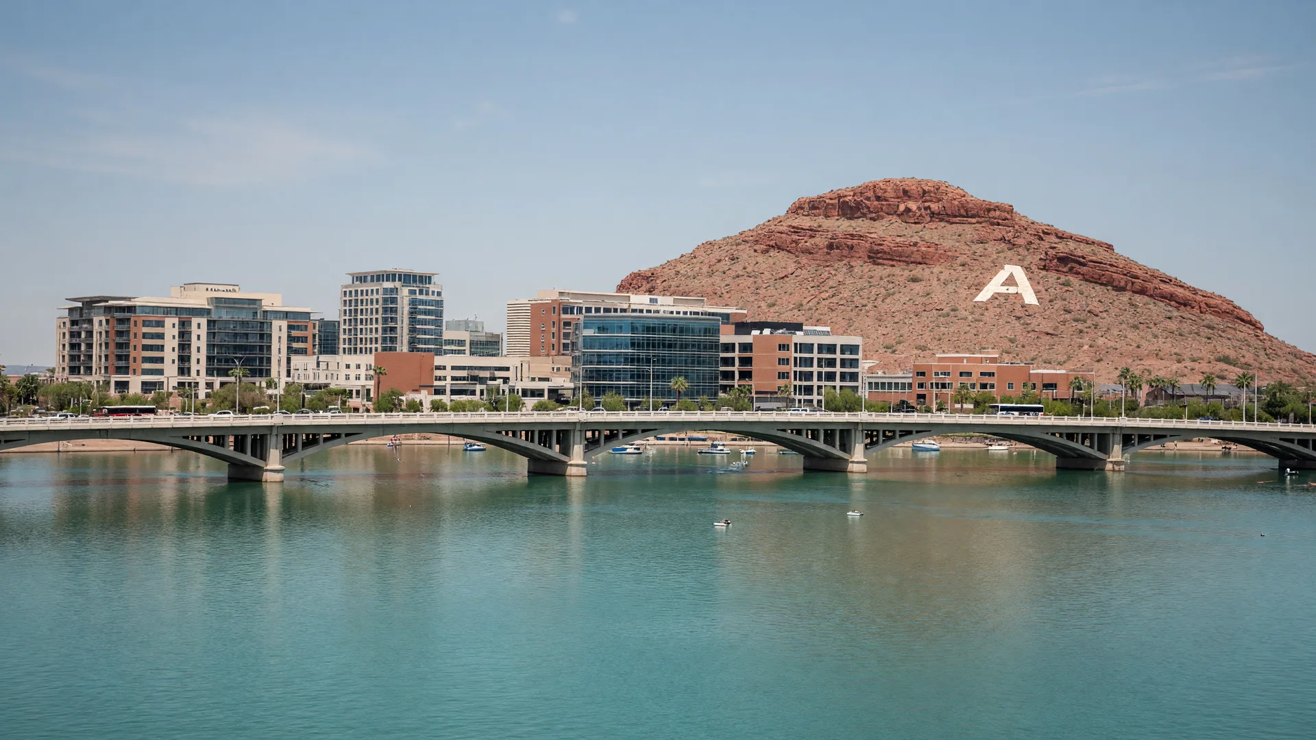 Tempe Town Lake at sunset with the Mill Avenue bridge, kayakers, and the ASU skyline behind