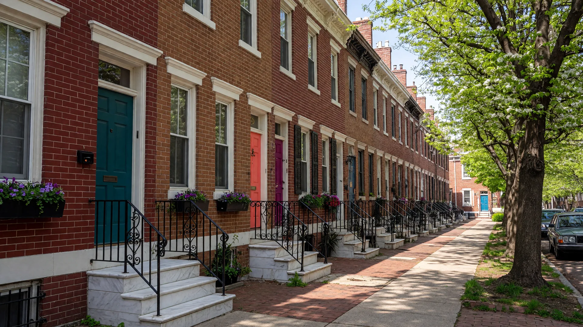 Historic brick rowhomes on a tree-lined street in Queen Village, Philadelphia