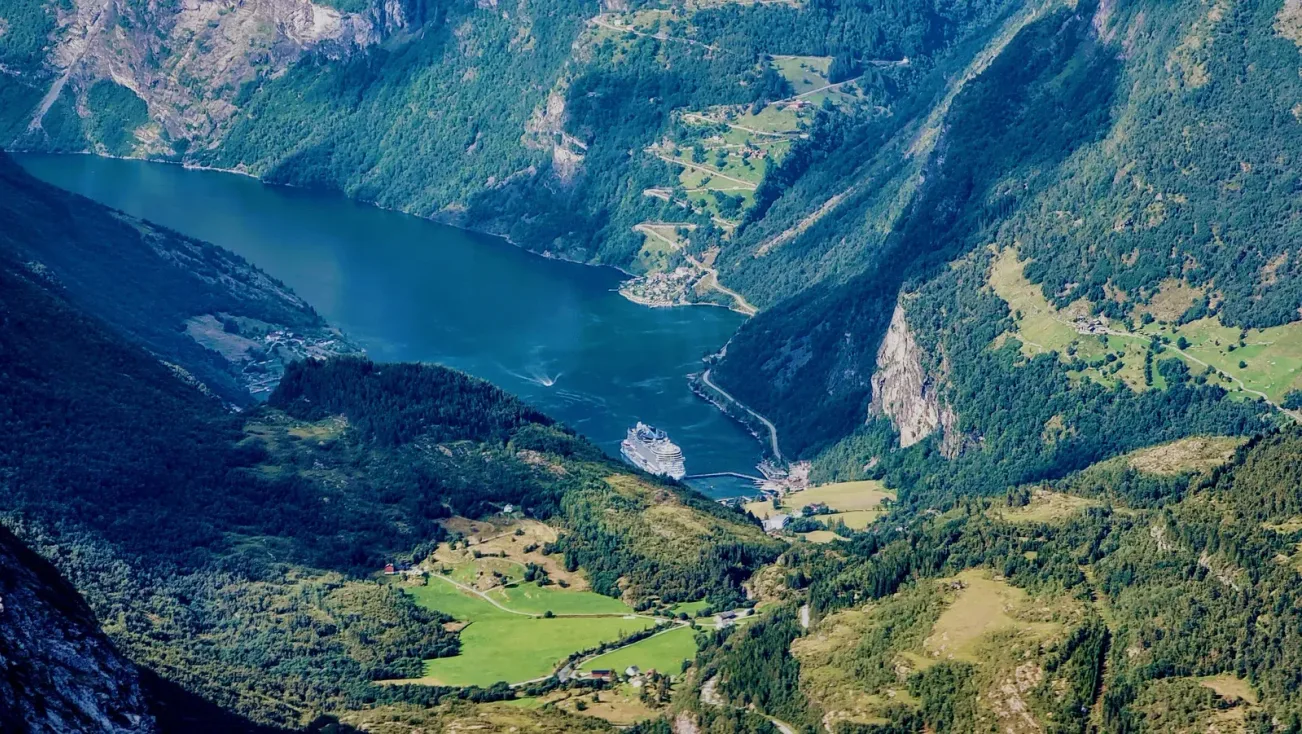 Geirangerfjord con acantilados verdes que caen al agua oscura, Noruega