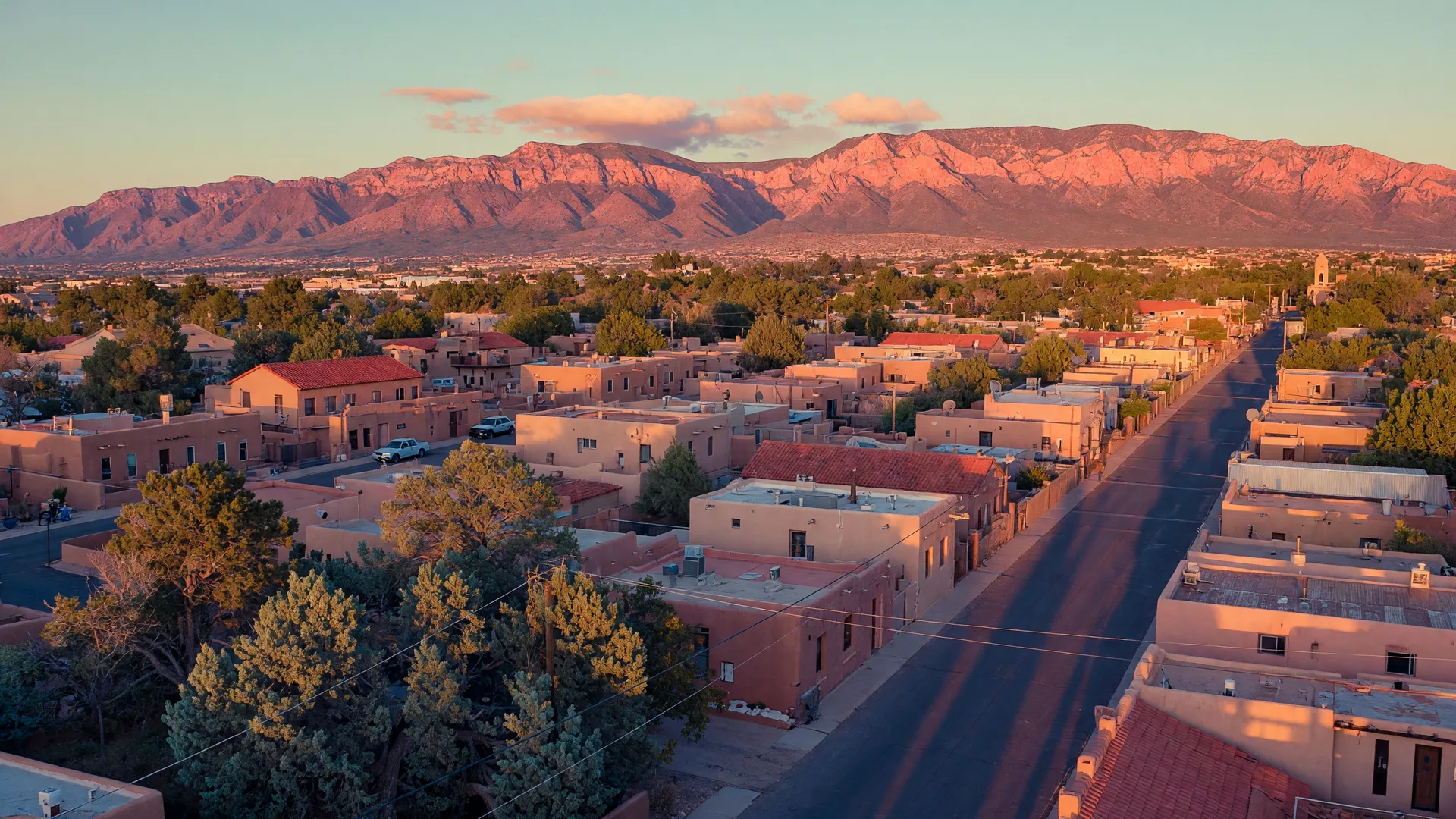 Albuquerque rooftops at golden hour with the Sandia Mountains rising behind them