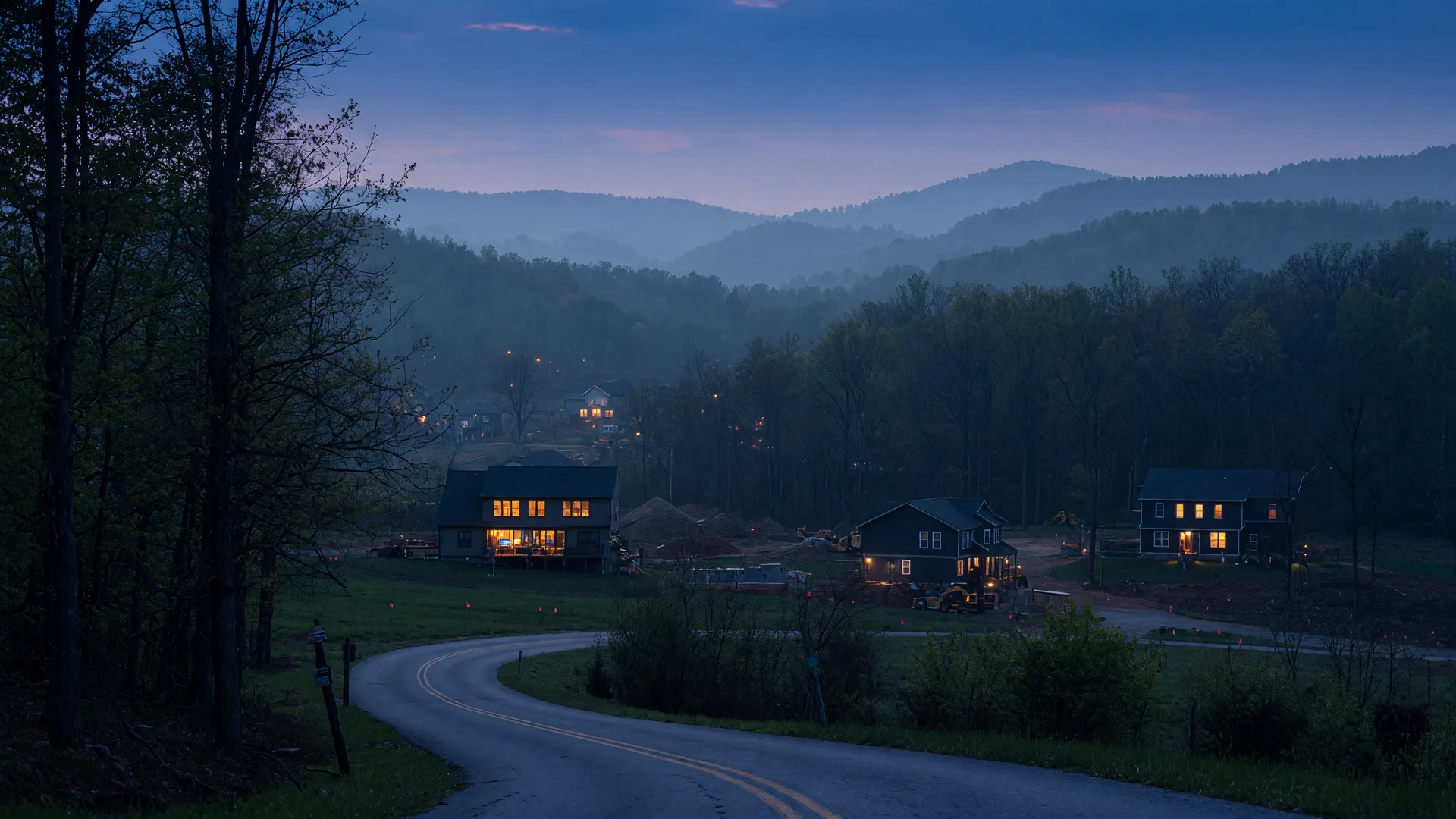 Warm-lit homes at the edge of a growing Kentucky town at blue hour