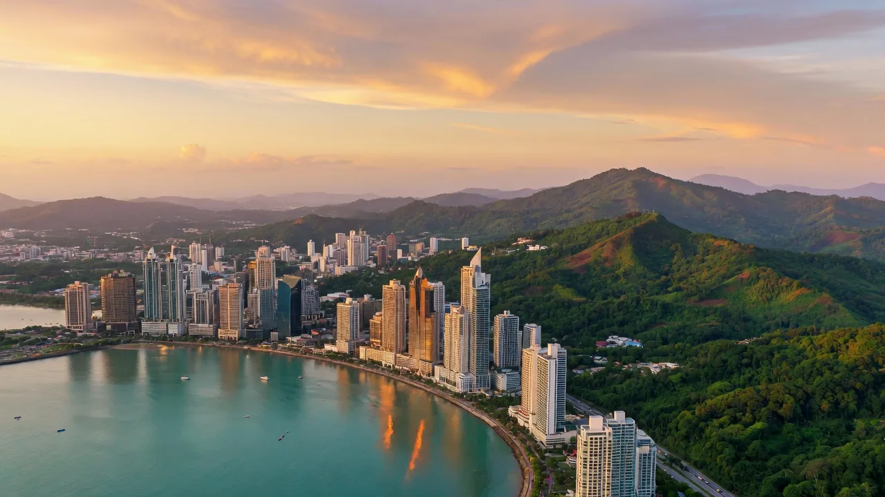 Panama City skyline along the bay with green highland hills behind